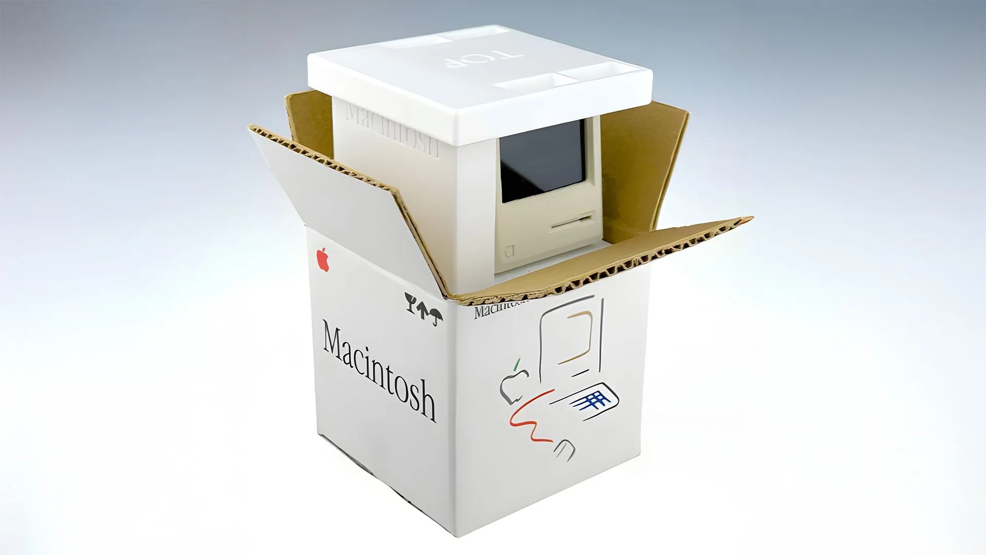 Bản sao máy tính Macintosh tí hon đặt cạnh ngón tay cái