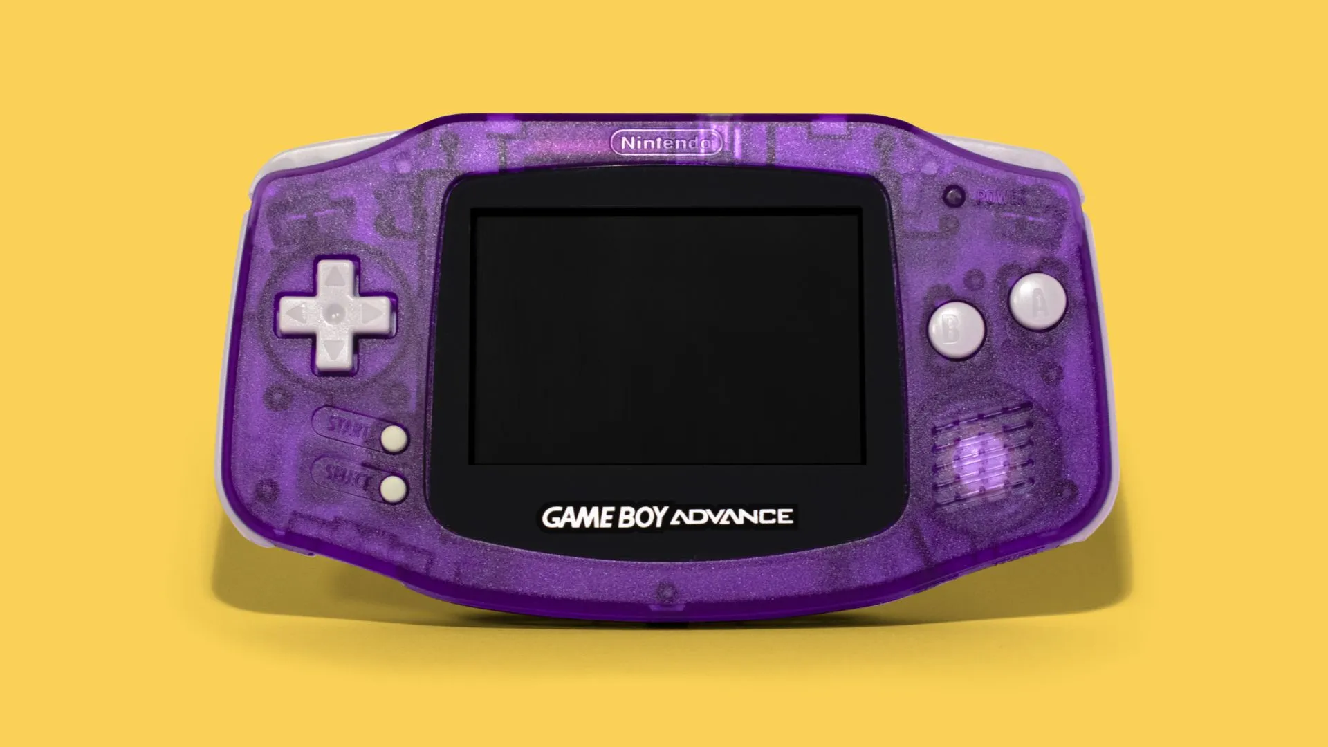 Cận cảnh chiếc máy chơi game cầm tay Nintendo Game Boy Advance màu trắng, cho thấy các nút điều khiển và màn hình, là đối thủ cạnh tranh chính của Nokia N-Gage thời bấy giờ.