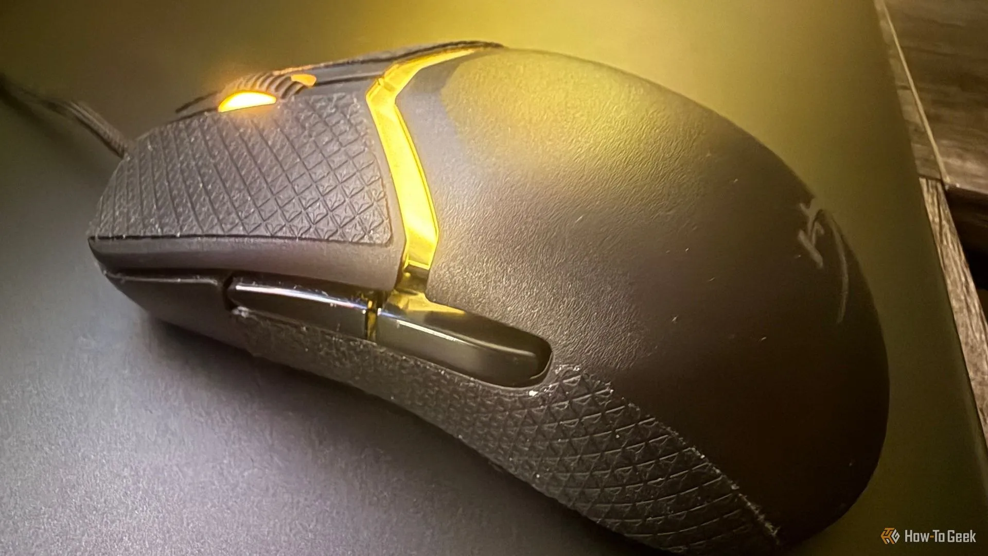 Cận cảnh nút bấm, cuộn chuột và lớp băng dán chống trượt trên chuột HyperX Pulsefire Saga.