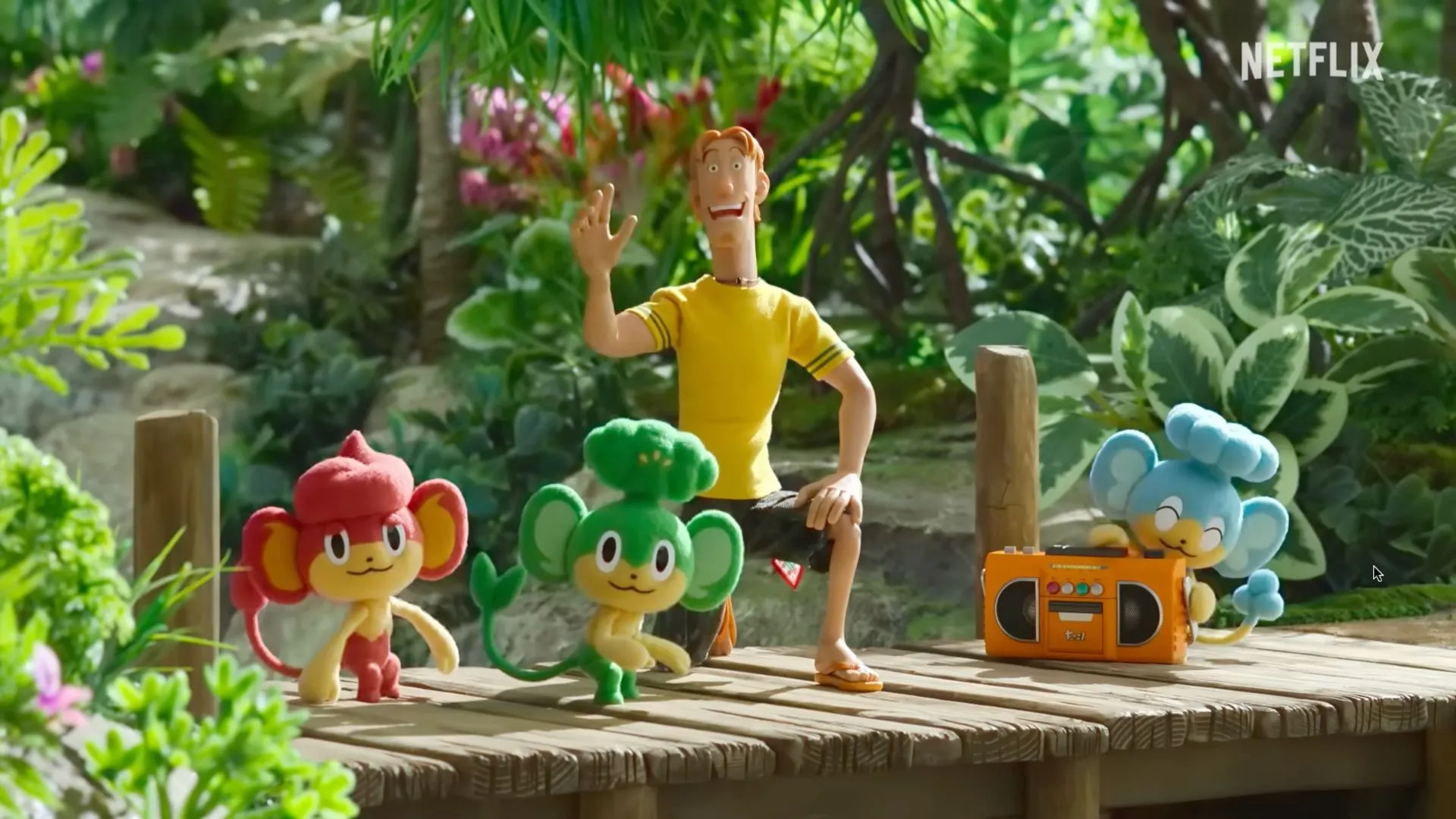 Cảnh phim hoạt hình Pokémon Concierge trên Netflix, với ba chú Pokémon khỉ và một người đàn ông mặc áo phông vàng