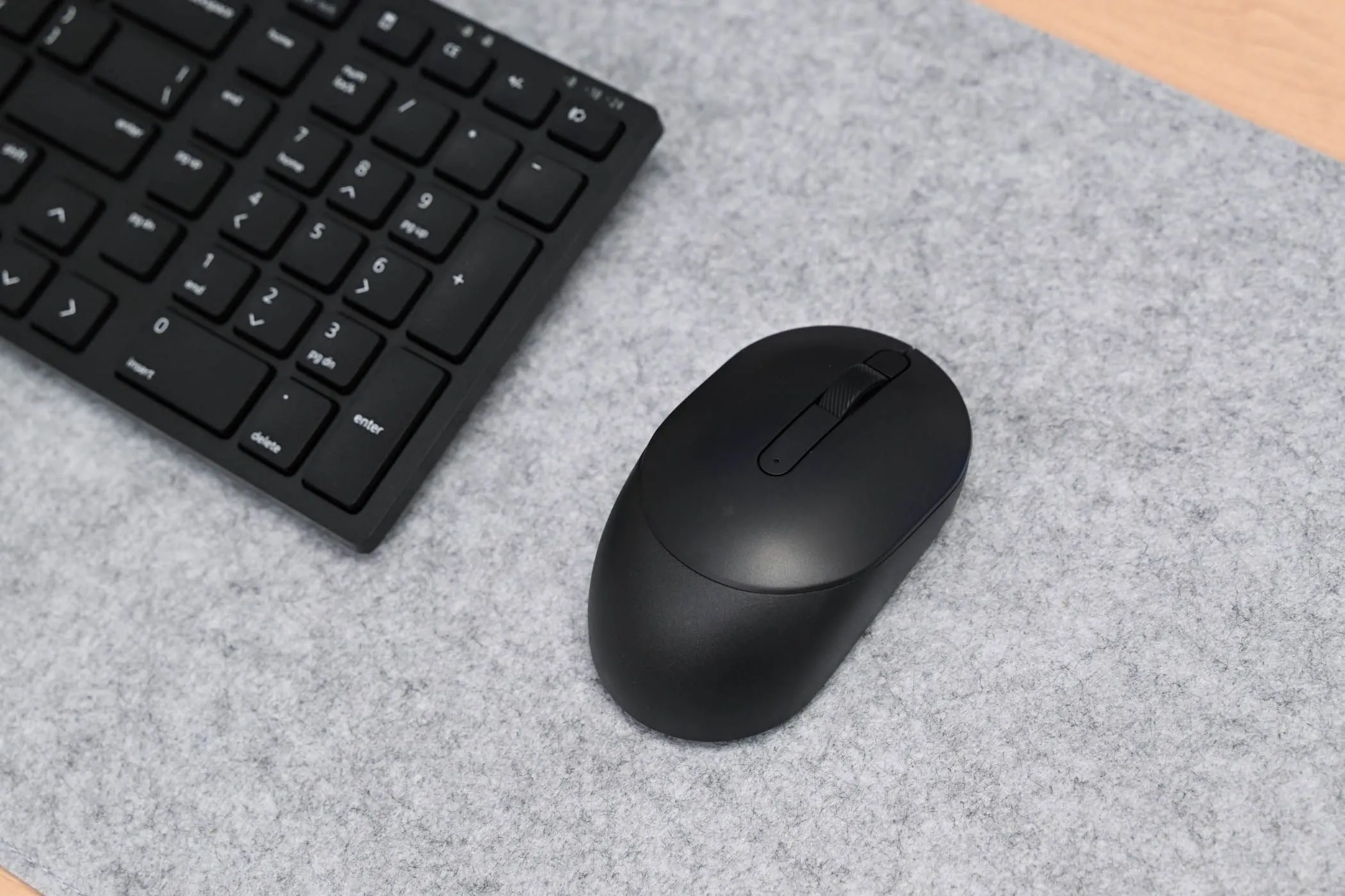 Chuột Dell Silent đặt cạnh bàn phím Dell Silent Keyboard (KM555), tối ưu cho trải nghiệm làm việc di động với điện thoại.