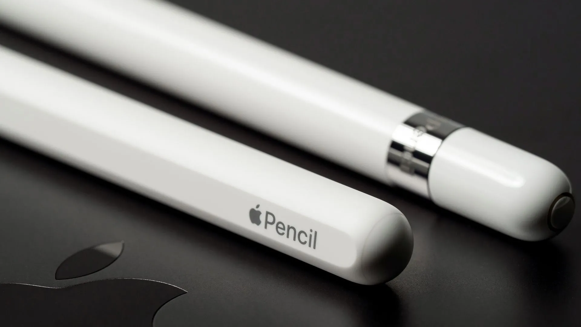 Hai chiếc Apple Pencil nằm trên một chiếc Macbook Pro, tượng trưng cho sự kết hợp giữa công nghệ sáng tạo và năng suất