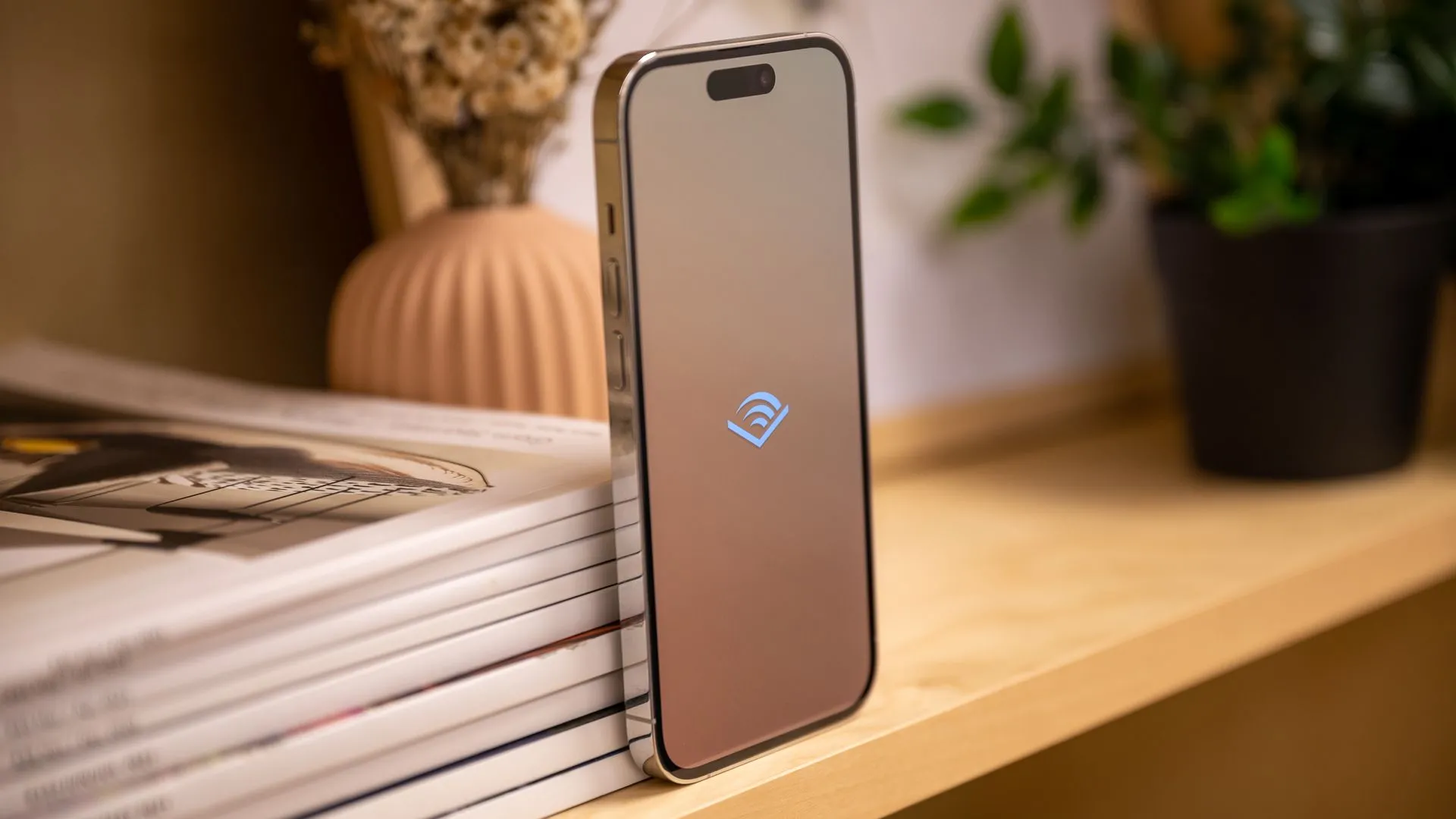 iPhone 14 Pro hiển thị logo Audible, biểu trưng cho việc nghe sách nói trên điện thoại.