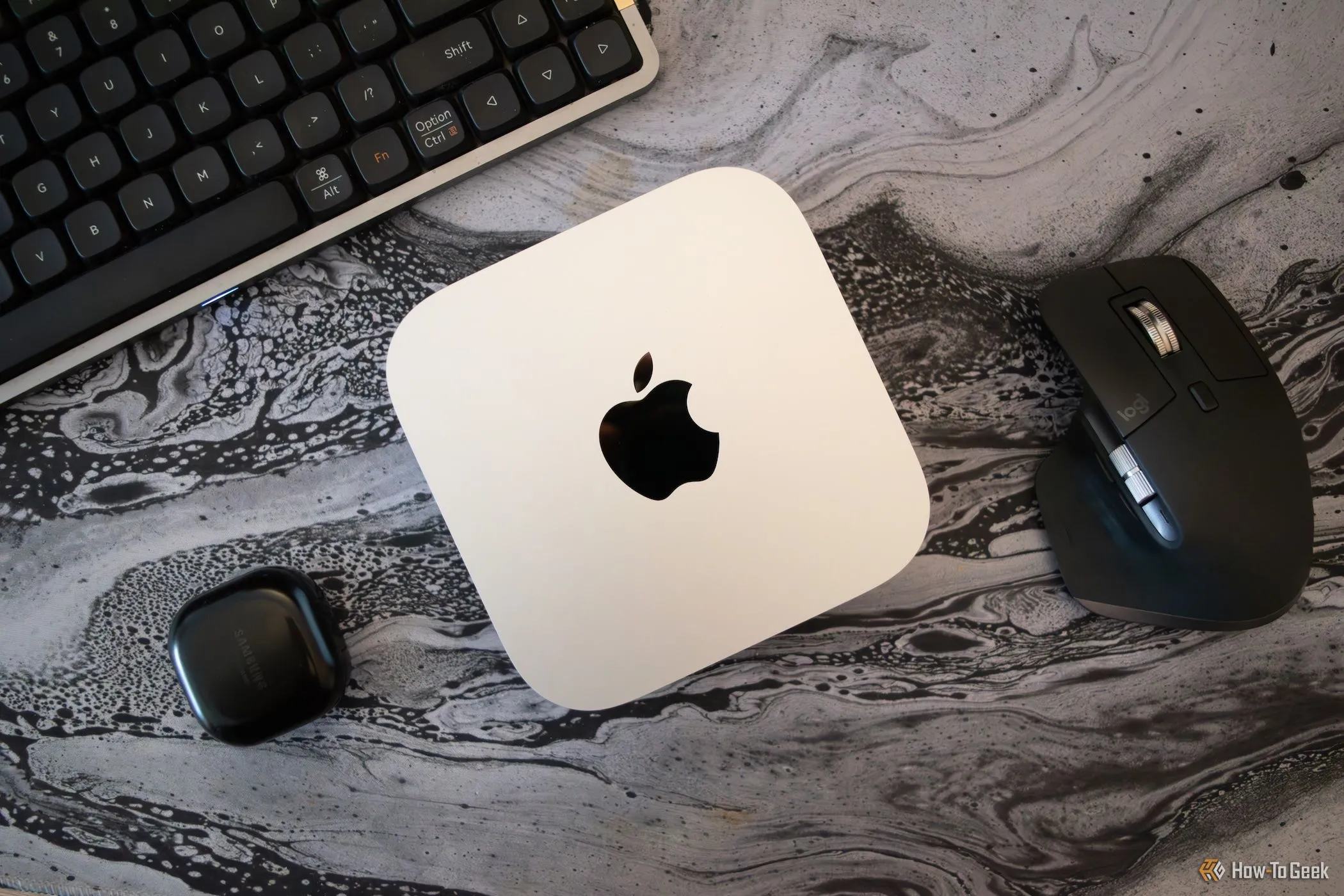 Mac Mini M4 trên bàn làm việc với các thiết bị ngoại vi PC