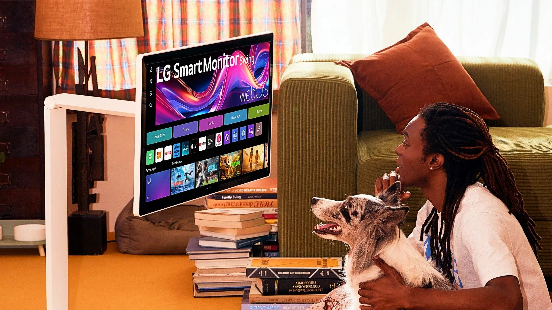 Màn hình LG Smart Monitor Swing được một người đàn ông và chó sử dụng trên sàn nhà