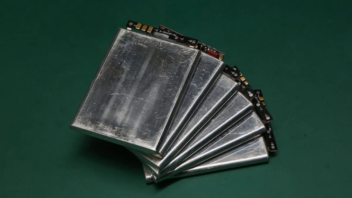 Một bộ pin lithium-ion được xếp dàn trải trên bề mặt, nhấn mạnh sự cần thiết phải xử lý và tái chế pin cũ một cách riêng biệt và an toàn để tránh nguy hiểm.