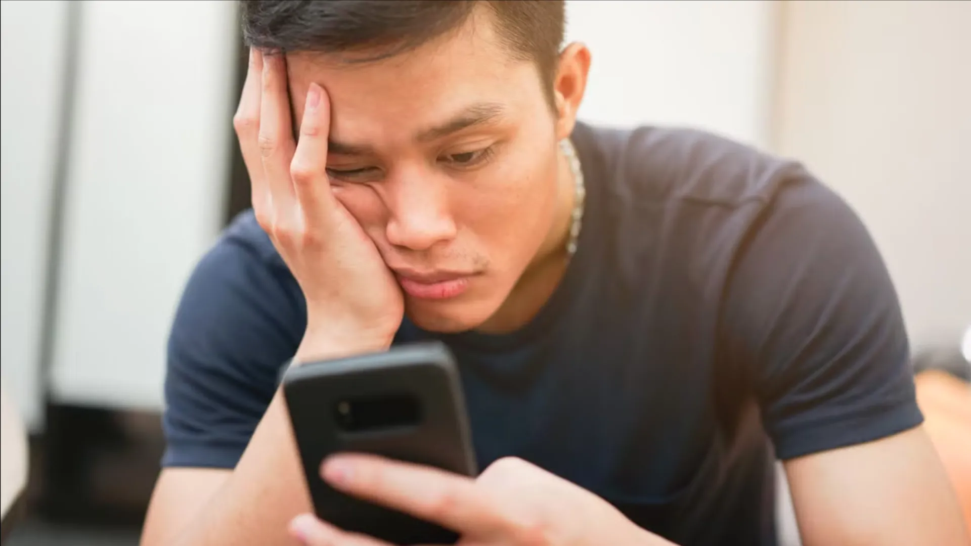 Người dùng lướt điện thoại với vẻ mặt nhàm chán, biểu tượng của sự phân tâm