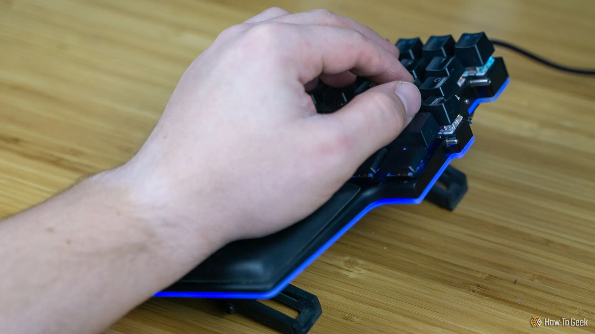 Người dùng thao tác với các phím ngón cái tùy chỉnh trên bàn phím Dygma Raise, minh họa khả năng gán macro giúp tăng tốc độ làm việc và cải thiện công thái học.