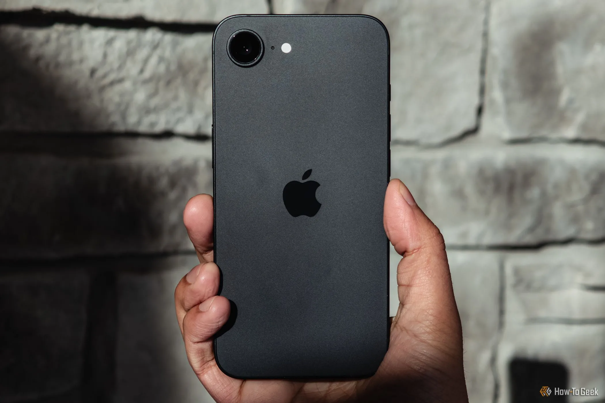 Người dùng trải nghiệm iPhone với giao diện iOS 26 mới dưới ánh nắng, minh họa sự thay đổi trong trải nghiệm người dùng