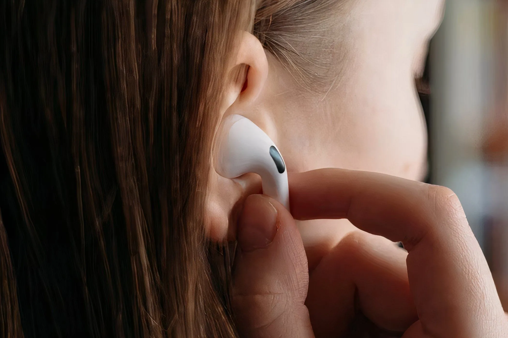 Người phụ nữ đang đặt AirPods Pro vào tai, minh họa tính tiện lợi của tai nghe không dây.