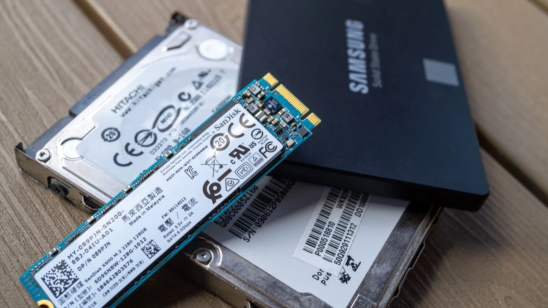 Ổ cứng SSD Samsung 850 EVO cùng các loại ổ cứng M.2 và SATA trên bàn, biểu trưng cho việc sao lưu dữ liệu quan trọng trước khi khôi phục hoặc dọn dẹp máy tính.