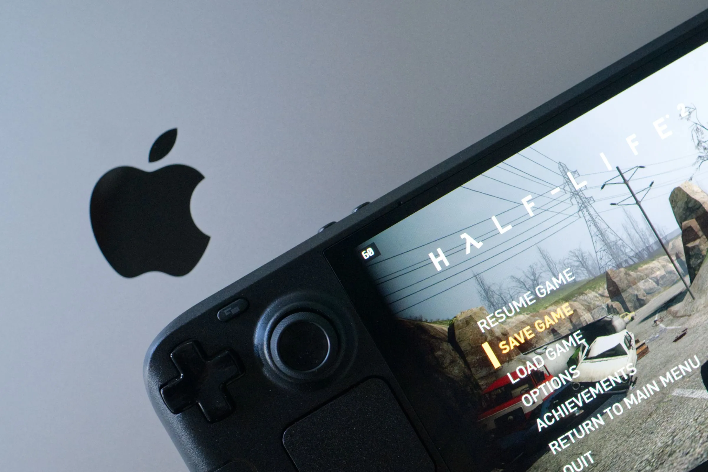 Tựa game Half-Life 2 đang chạy trên Steam Deck OLED đặt trên bàn phím của một chiếc MacBook Pro