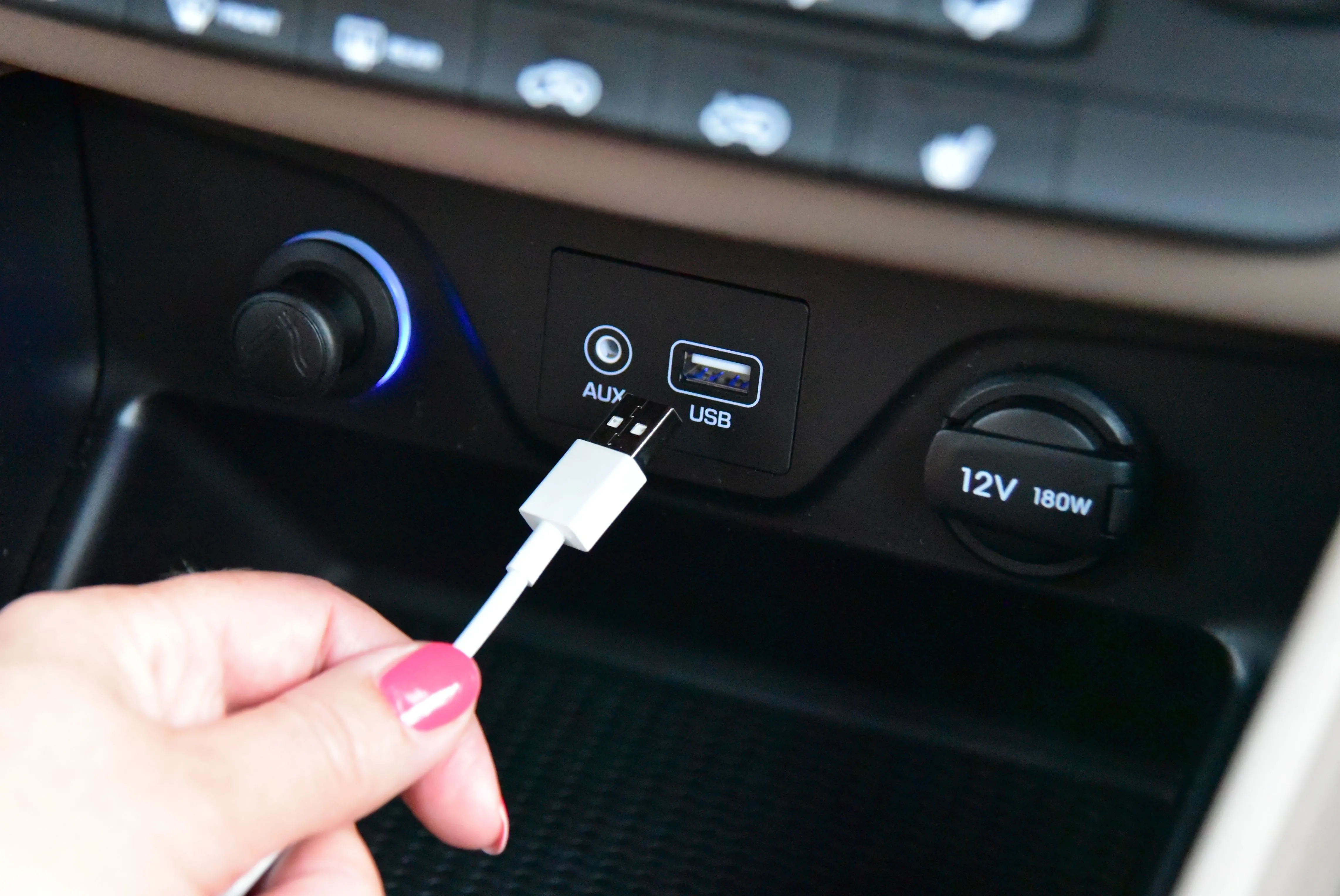 Bàn tay cắm cáp USB vào cổng trên bảng điều khiển ô tô