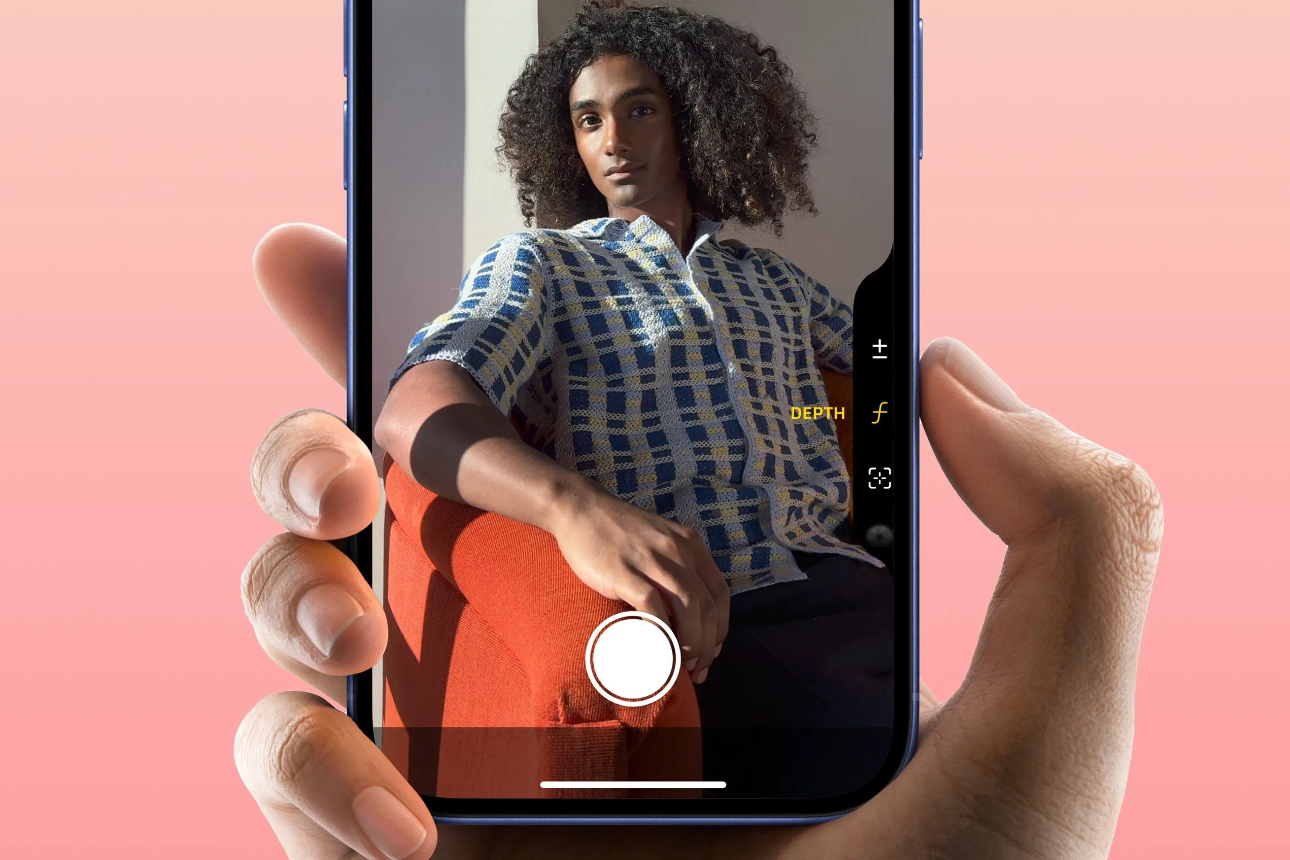 Bàn tay đang giữ iPhone 16, ngón trỏ chạm vào nút chụp Camera Control, minh họa thao tác trực quan khi sử dụng.