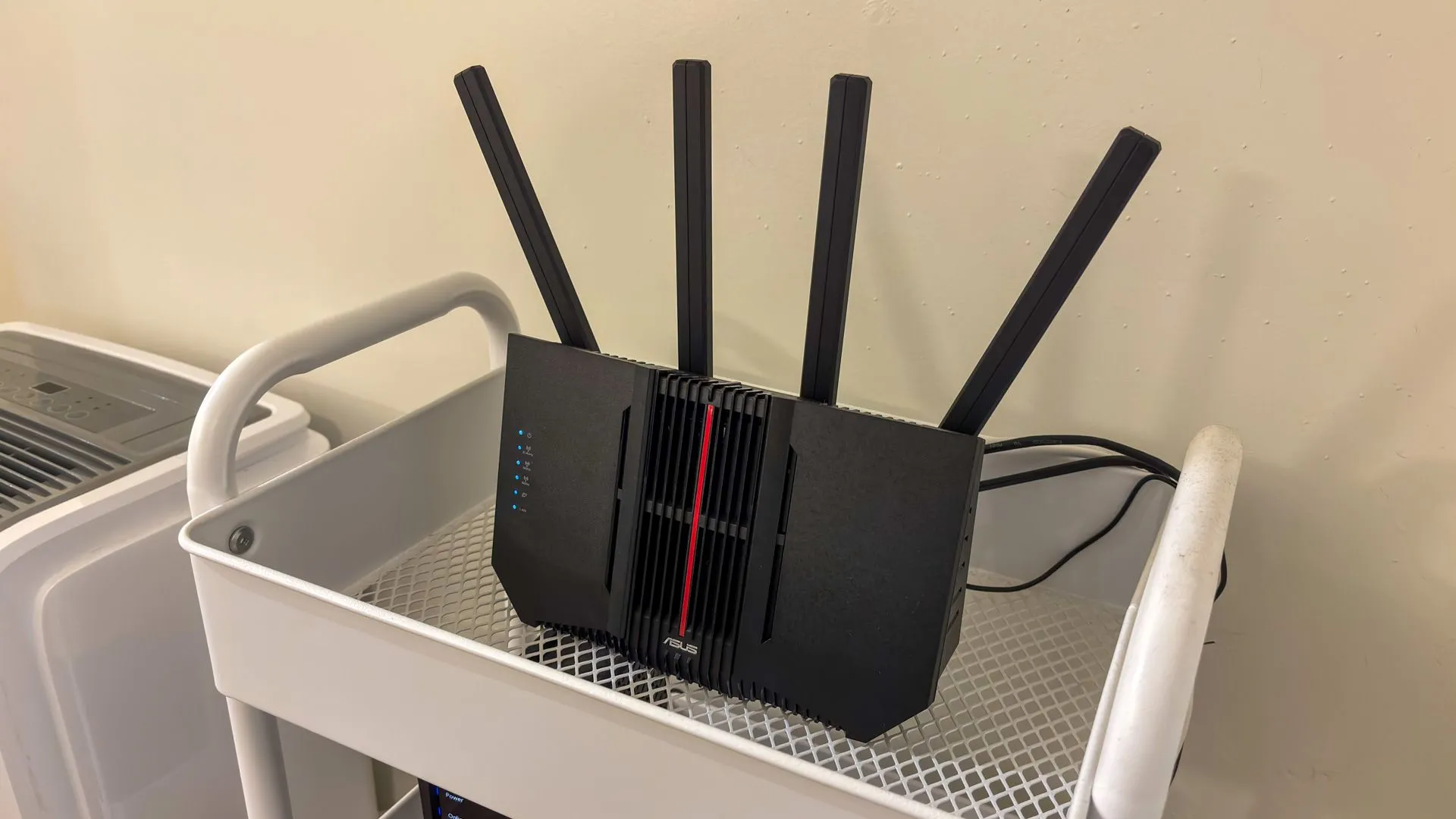 Bộ định tuyến ASUS trên kệ, biểu thị cho chất lượng kết nối Wi-Fi có thể ảnh hưởng đến pin Chromebook.