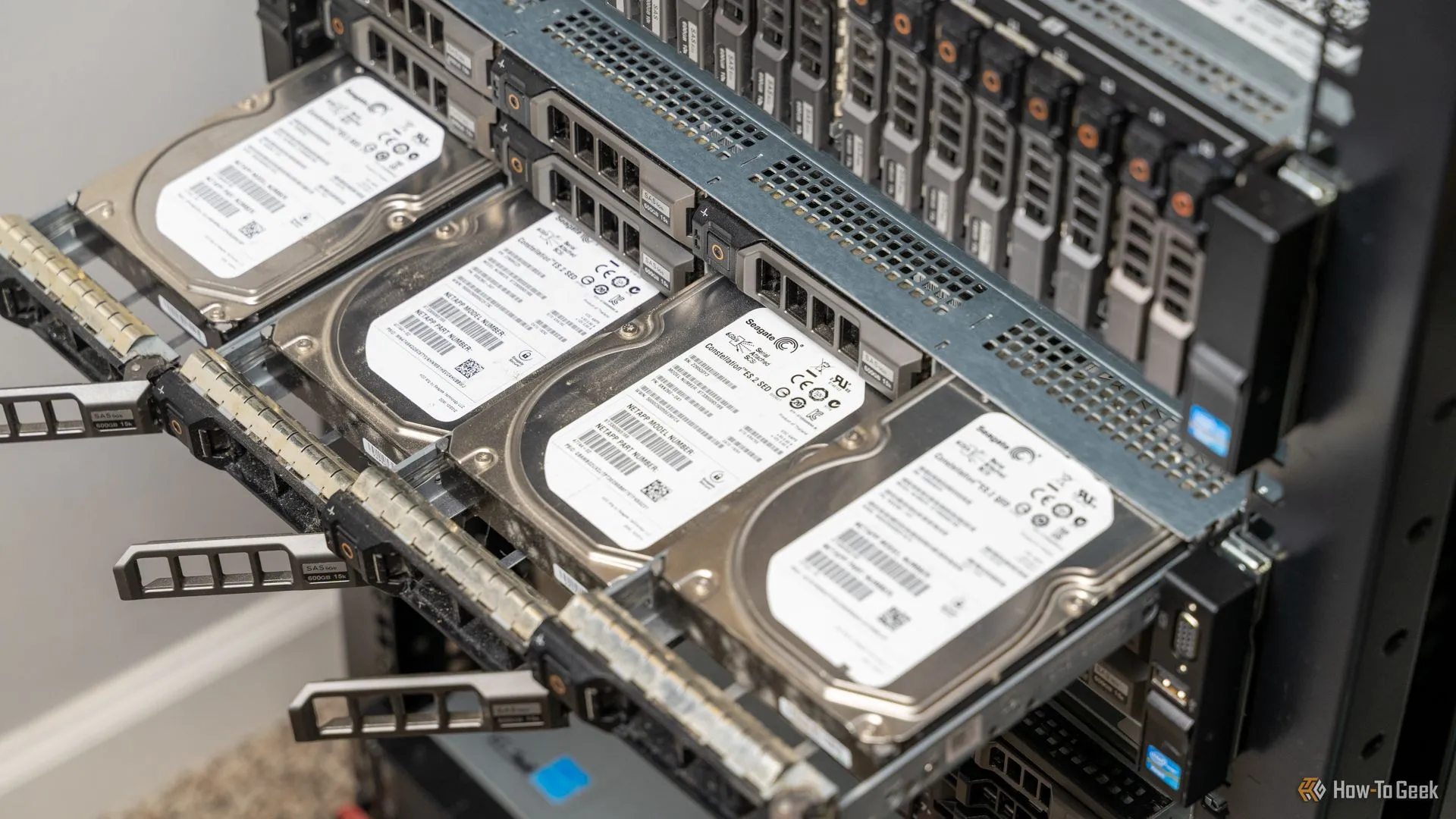 Bốn ổ cứng HDD được rút ra từ máy chủ rack-mount, tượng trưng cho việc tìm kiếm và nâng cấp ổ cứng lưu trữ từ các kênh đồ cũ cho hệ thống homelab.