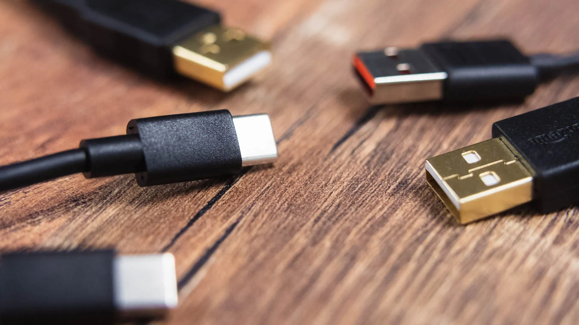 Cận cảnh các đầu nối cáp sạc USB-A và USB-C trên các sợi dây cáp, làm nổi bật sự phức tạp khi phân biệt chúng chỉ qua hình dáng đầu cắm.