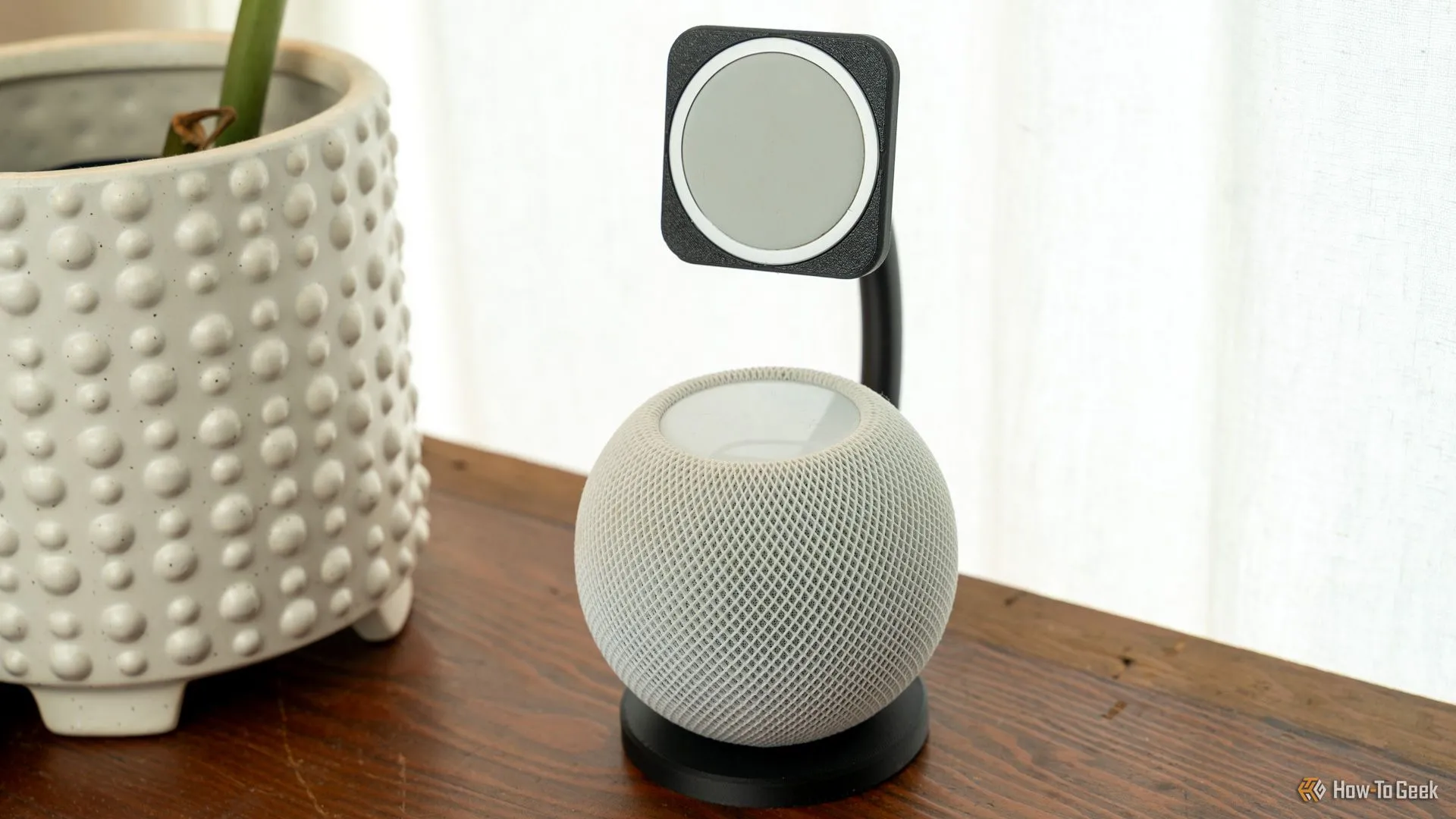 Đế sạc MagSafe in 3D tích hợp HomePod mini trên bàn gỗ.