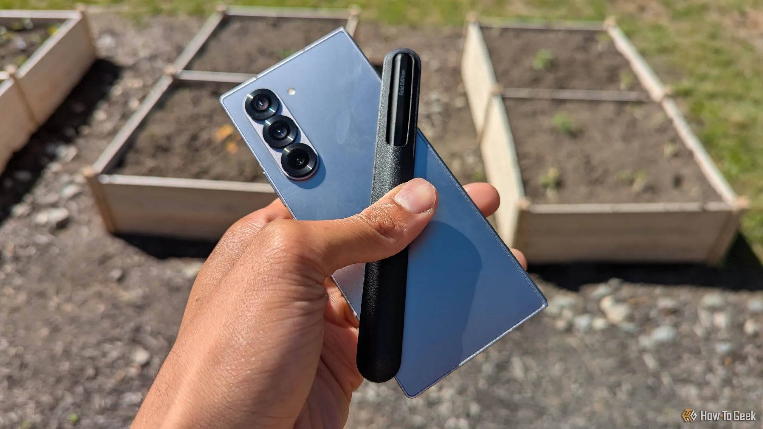 Điện thoại Samsung Galaxy Z Fold 6 và bút S Pen đặt trong khung cảnh khu vườn, nhấn mạnh tính di động và linh hoạt làm việc