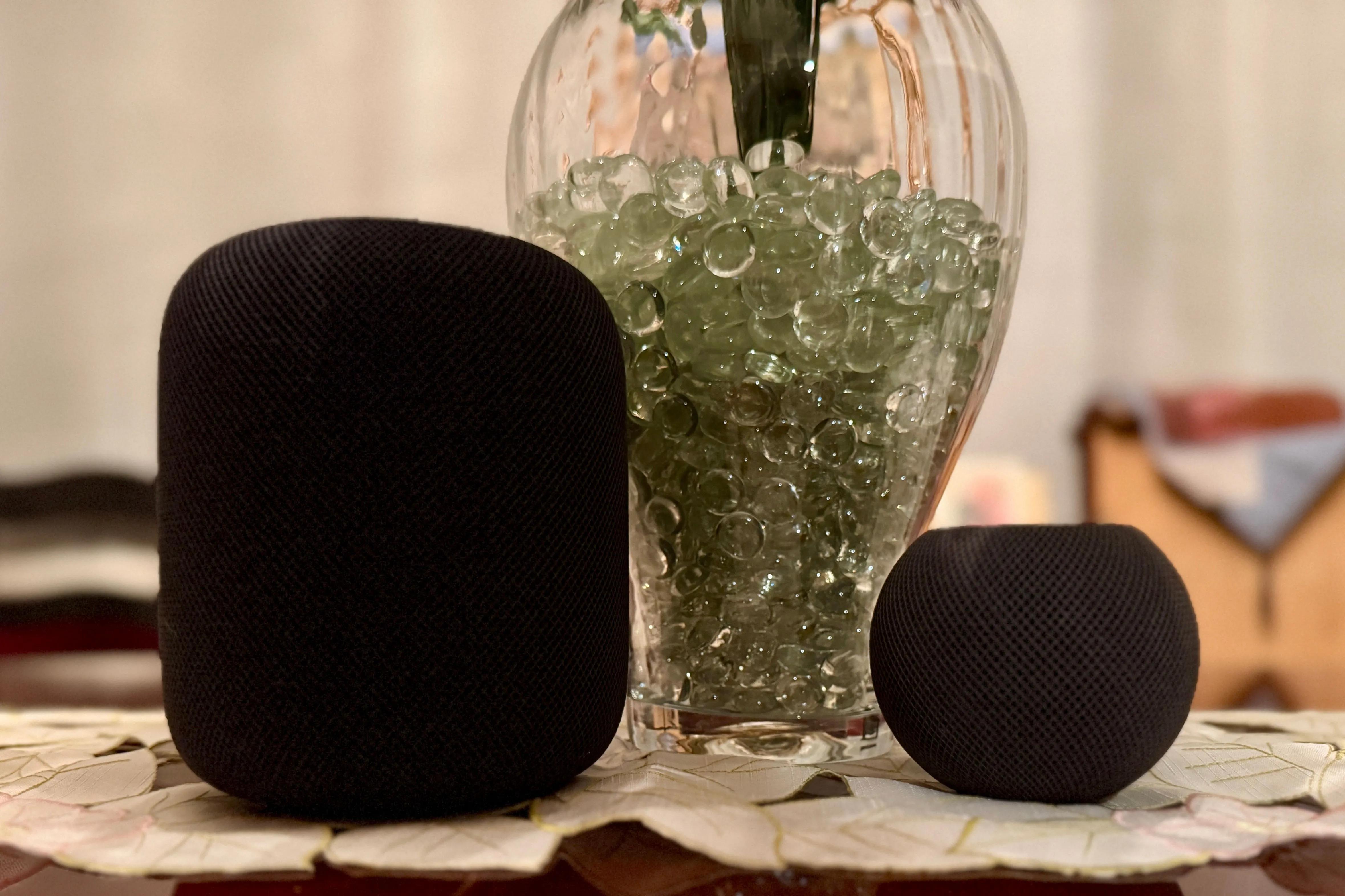 Hai loa HomePod thế hệ 2 màu đen đặt cạnh một chiếc bình trang trí, thể hiện tính thẩm mỹ và khả năng hòa nhập vào không gian sống.