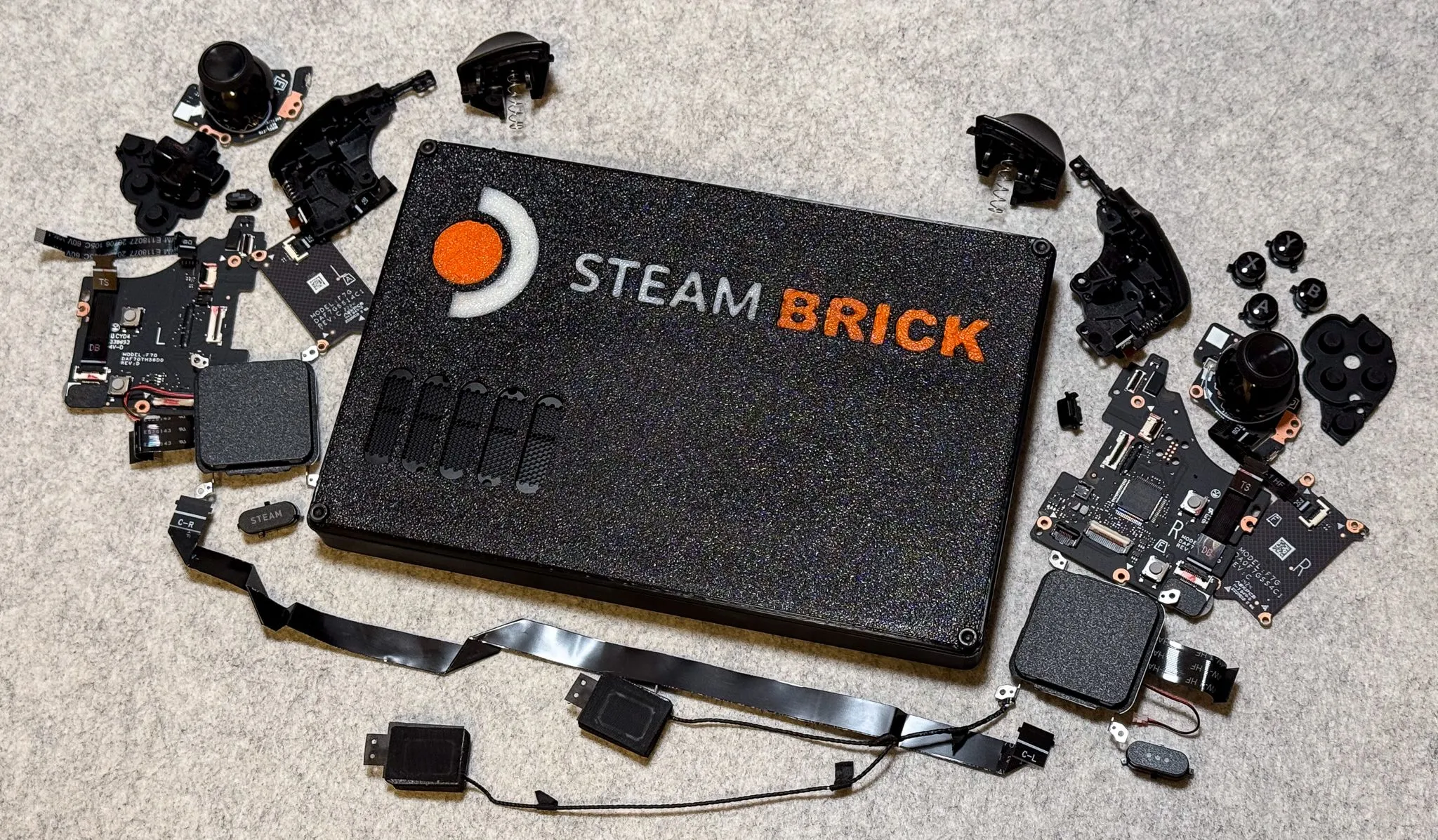 Hình ảnh cận cảnh thiết bị &quot;Steam Brick&quot; - phiên bản Steam Deck thu gọn thành PC mini, không màn hình, cho thấy kích thước nhỏ gọn và thiết kế vỏ in 3D.