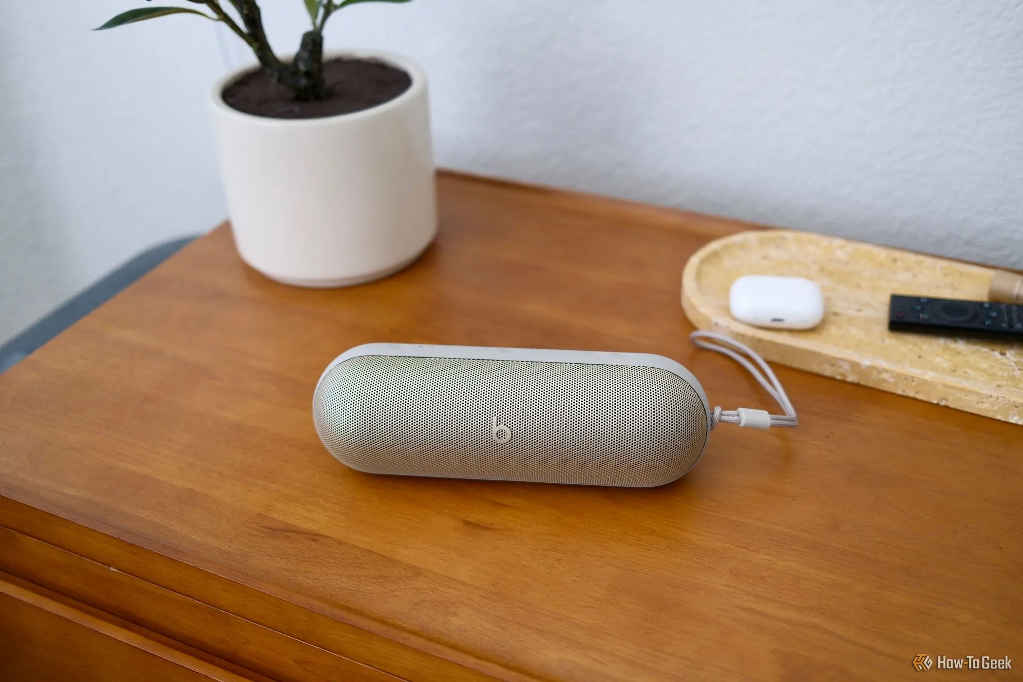 Loa di động Beats Pill màu đen nằm trên bàn gỗ