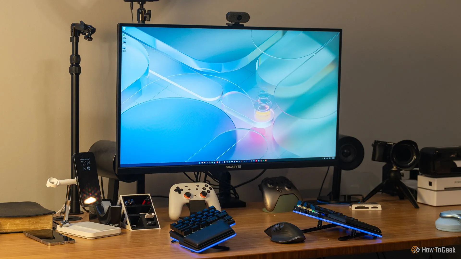 Màn hình gaming 4K 16:9 của GIGABYTE trên bàn làm việc cùng bàn phím, bộ điều khiển và phụ kiện, minh họa cho không gian chơi game chuyên nghiệp.
