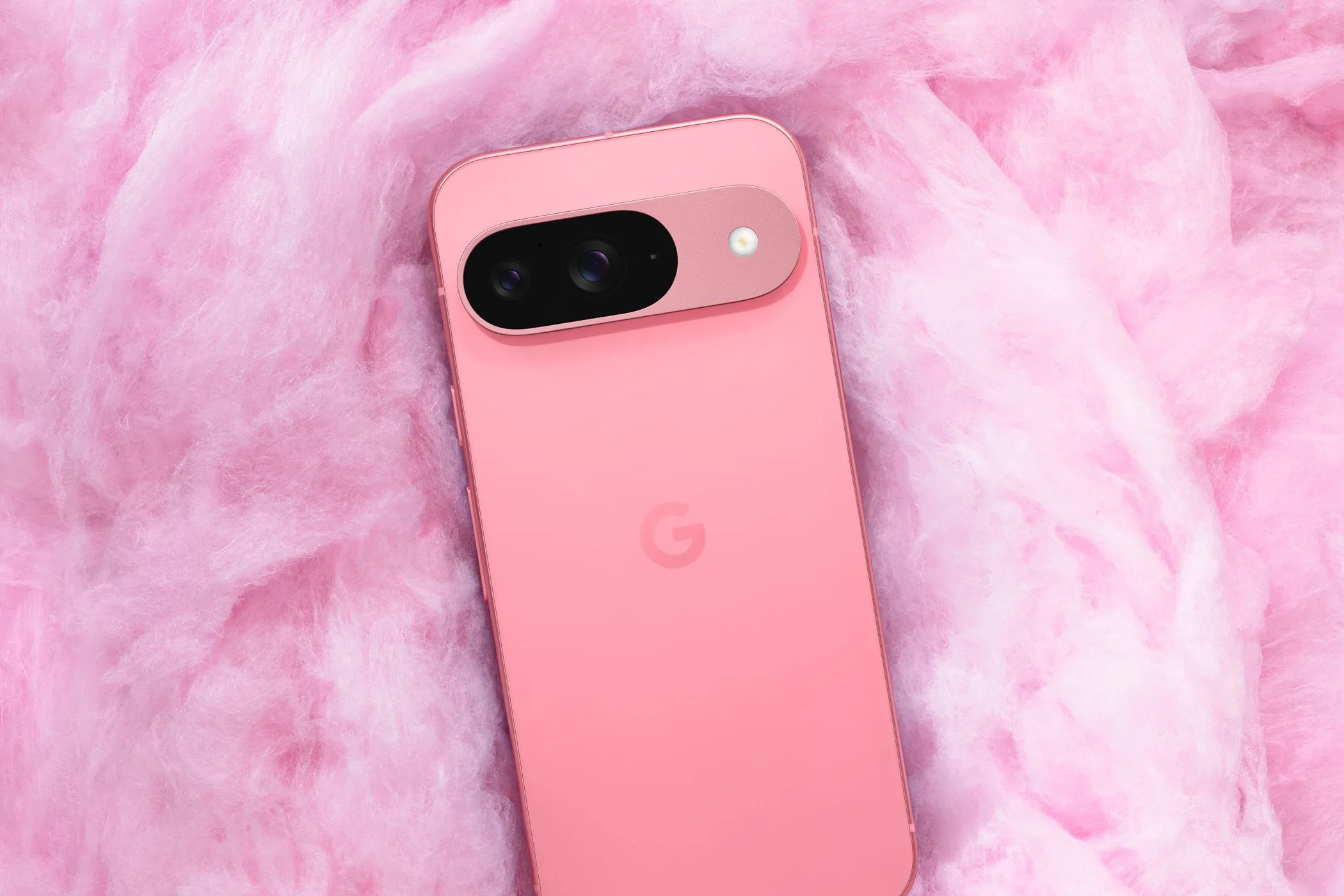 Mặt lưng của điện thoại Google Pixel 9 màu hồng nhạt, làm nổi bật thiết kế thanh camera đặc trưng, dùng để so sánh chất lượng camera với Pixel 10