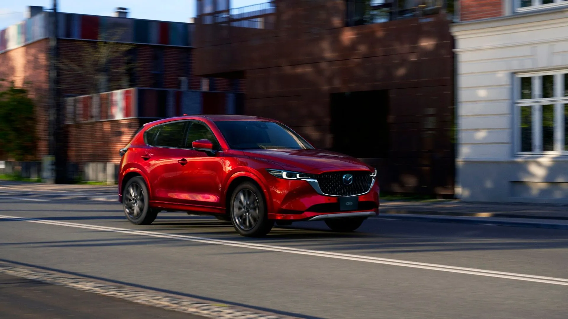 Mẫu xe Mazda CX-5 thế hệ mới màu đỏ đang đỗ trên đường nhựa, giới thiệu động cơ Skyactiv-Z.