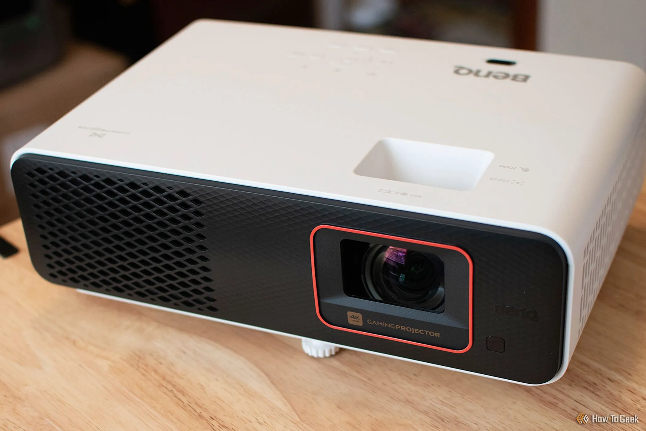 Máy chiếu chơi game BenQ X500i đặt trên mặt bàn, chiếu hình ảnh