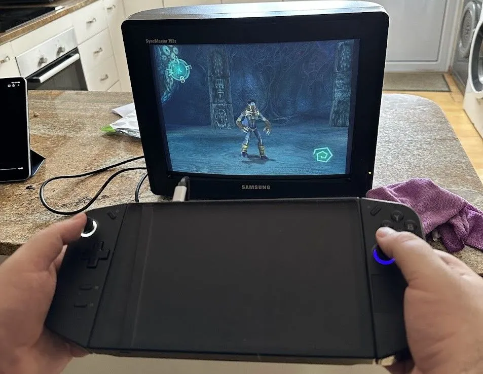 Máy chơi game cầm tay Lenovo Legion Go được cắm vào màn hình CRT, đang hiển thị cảnh game Legacy of Kain Soul Reaver 1 và 2 Remastered.