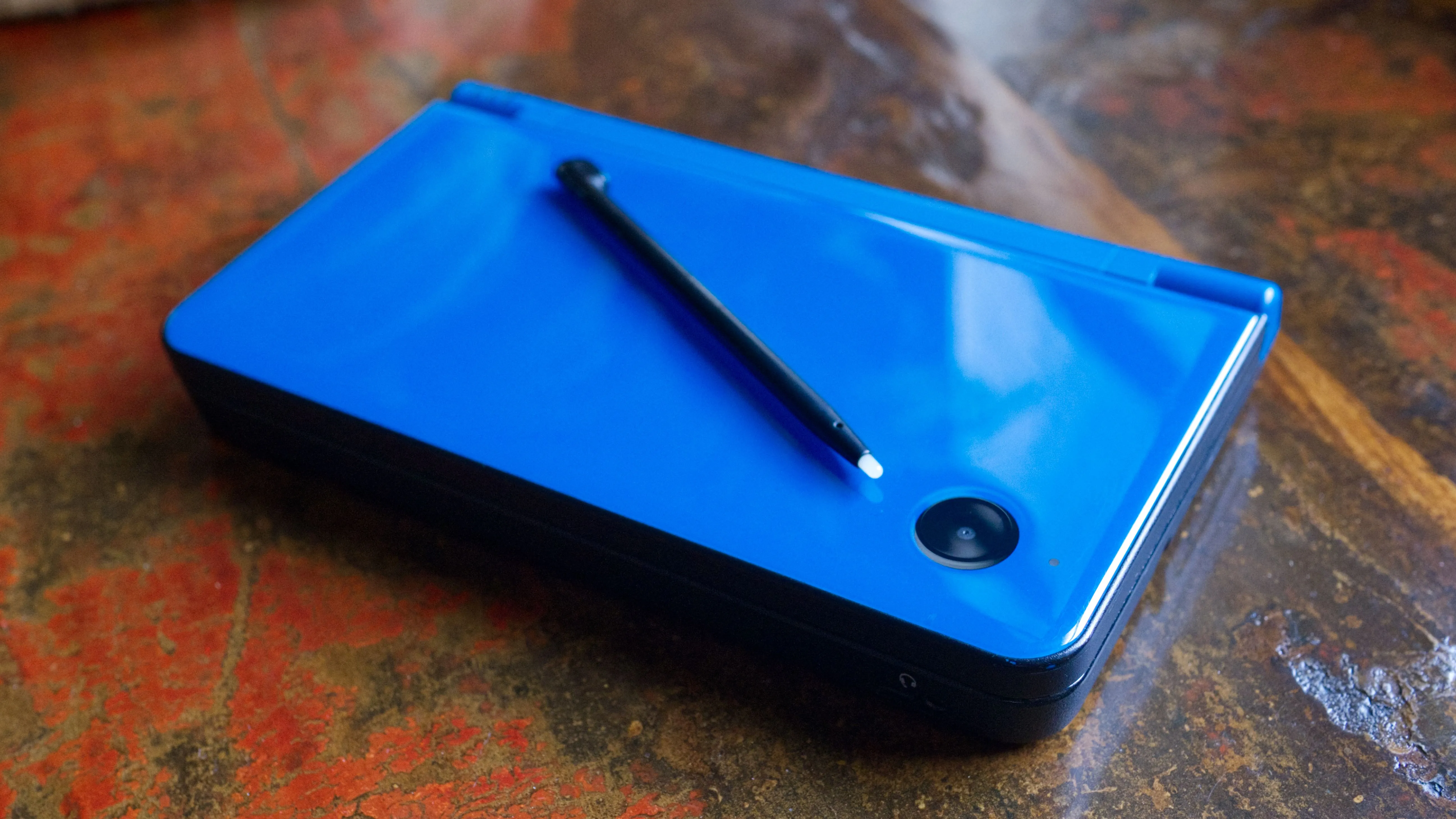Máy chơi game Nintendo DSi XL với thiết kế gập vỏ sò và hai màn hình đặc trưng.
