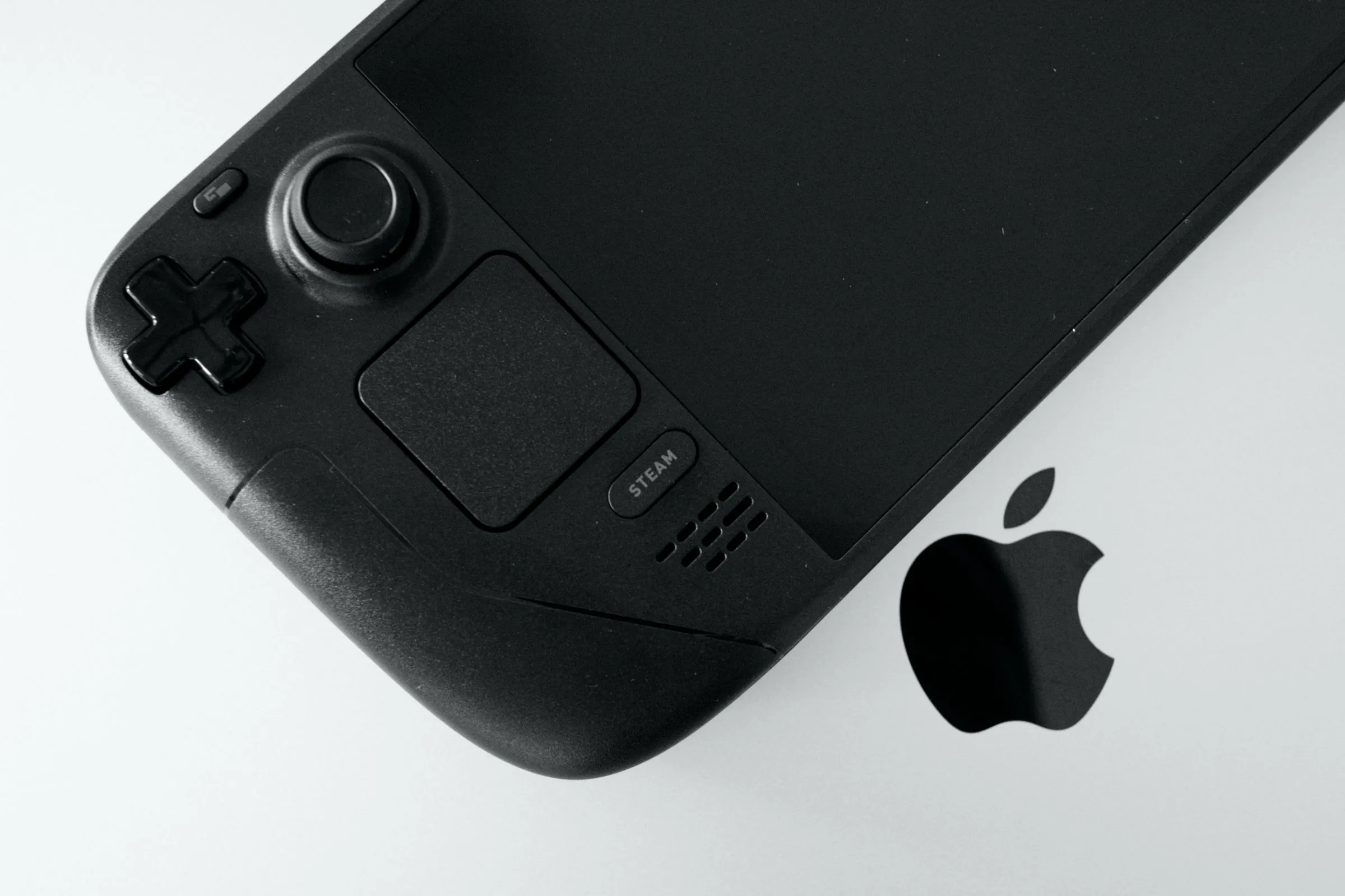 Mô hình Steam Deck OLED đặt trên MacBook Pro, minh họa khả năng giả lập game PS2 trên thiết bị di động.