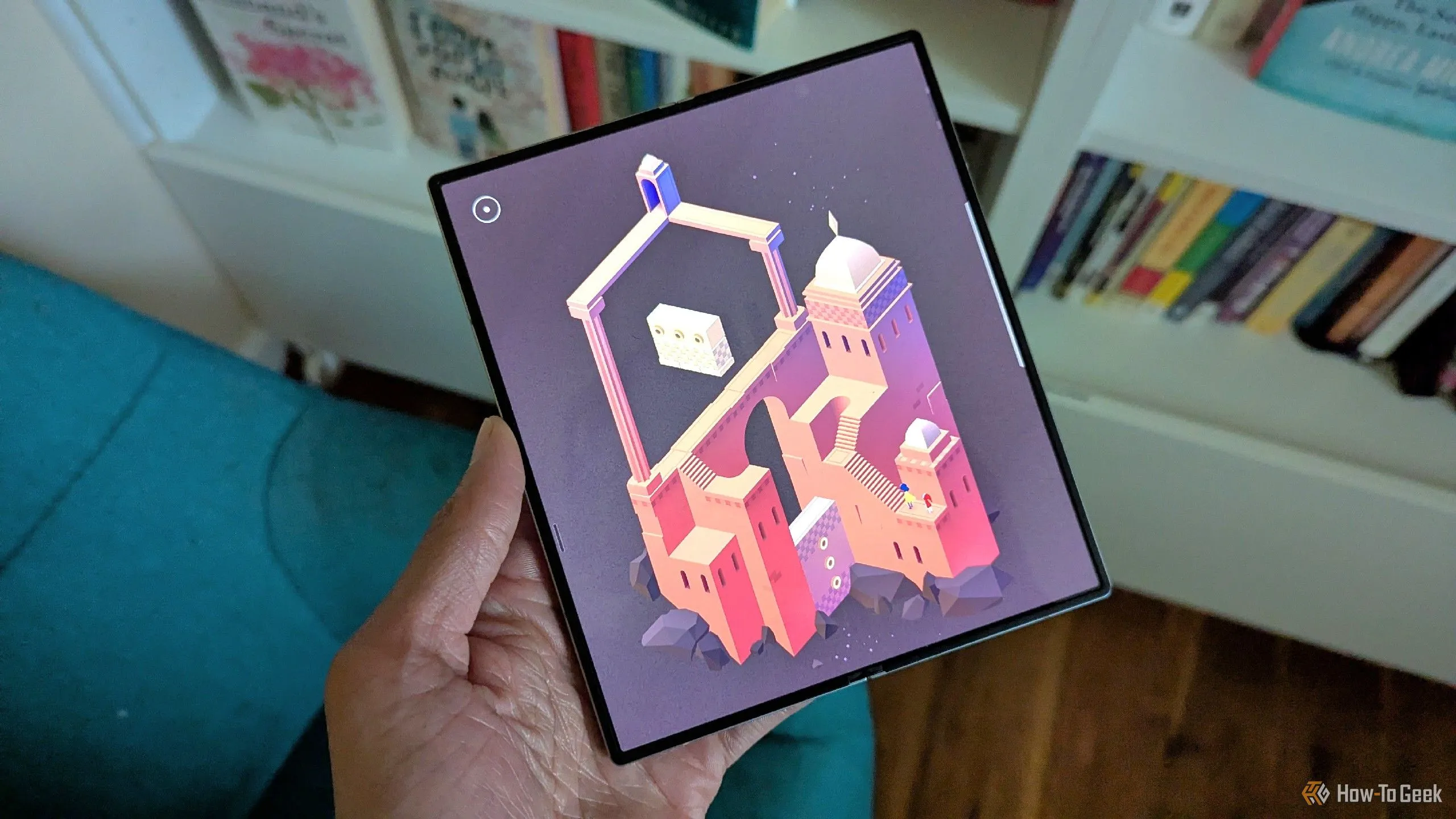 Monument Valley 2 trên Galaxy Z Fold 6 với sách ở phía sau, minh họa khả năng chơi game di động hiện đại.