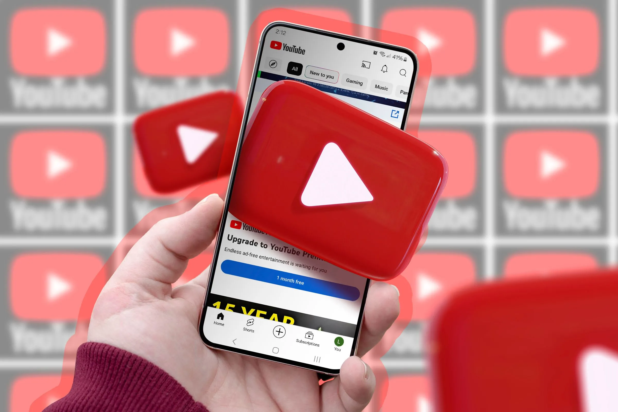 Một bàn tay đang cầm điện thoại hiển thị logo YouTube, thể hiện tính năng bỏ phiếu bài hát mới trên playlist cộng tác.