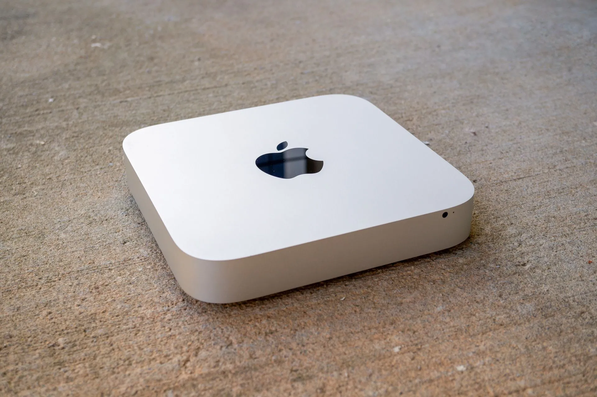 Một chiếc Mac mini đặt trên bề mặt bê tông, đại diện cho tính linh hoạt và khả năng tích hợp vào mọi không gian sống.