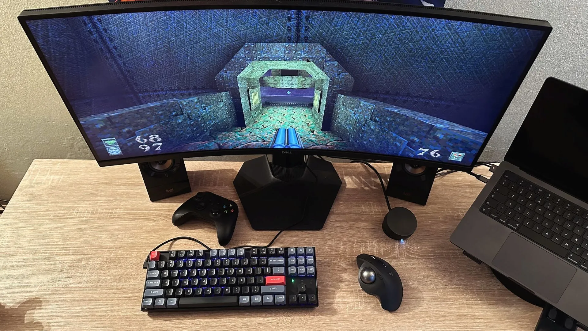 Một góc làm việc với màn hình hiển thị game Quake và chuột bi lăn (trackball mouse), gợi nhớ không khí chơi game PC những năm 90.