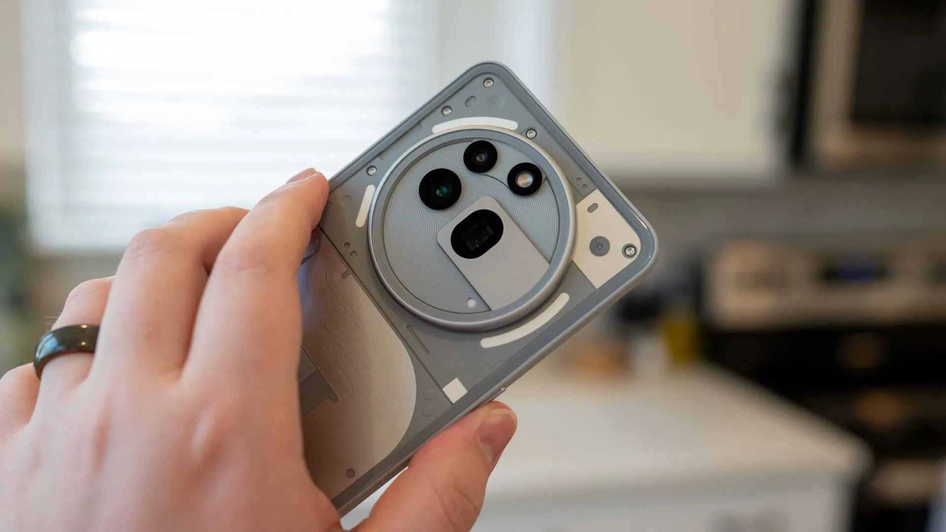 Một người cầm điện thoại Nothing Phone (3a) Pro, tập trung vào thiết kế camera sau độc đáo