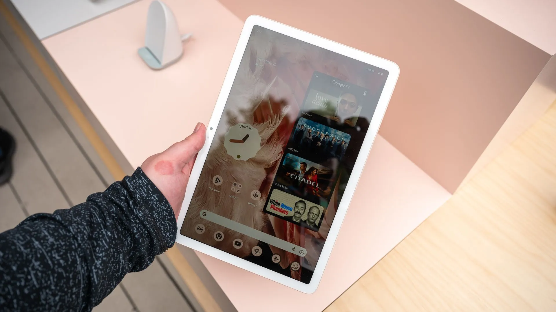 Một người đang cầm máy tính bảng Google Pixel Tablet theo chiều dọc, tận hưởng nội dung giải trí.