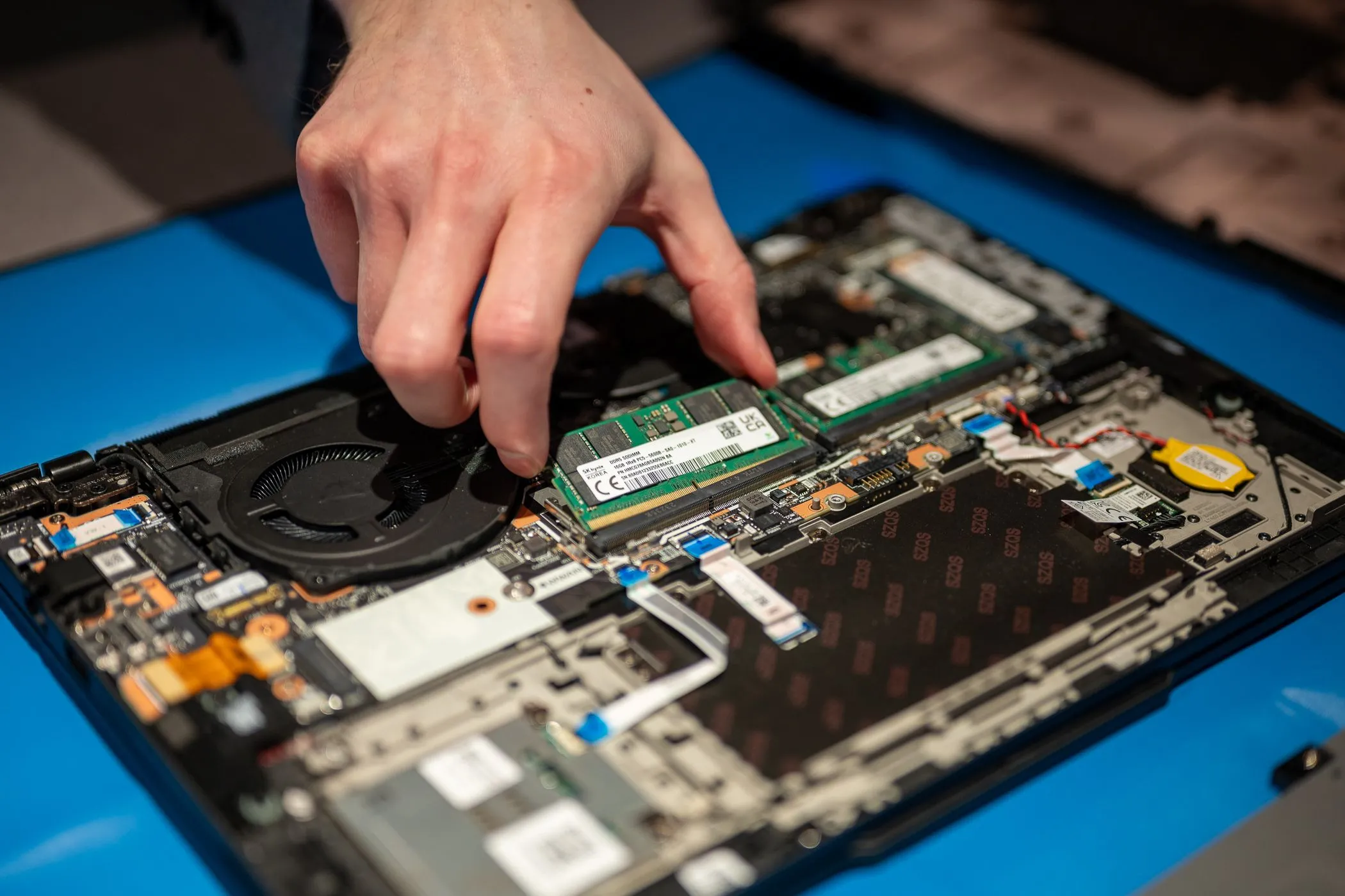 Nâng cấp RAM trên laptop Dell Latitude, tháo lắp thanh RAM để minh họa tầm quan trọng của RAM đối với hiệu năng chơi game trên laptop làm việc.