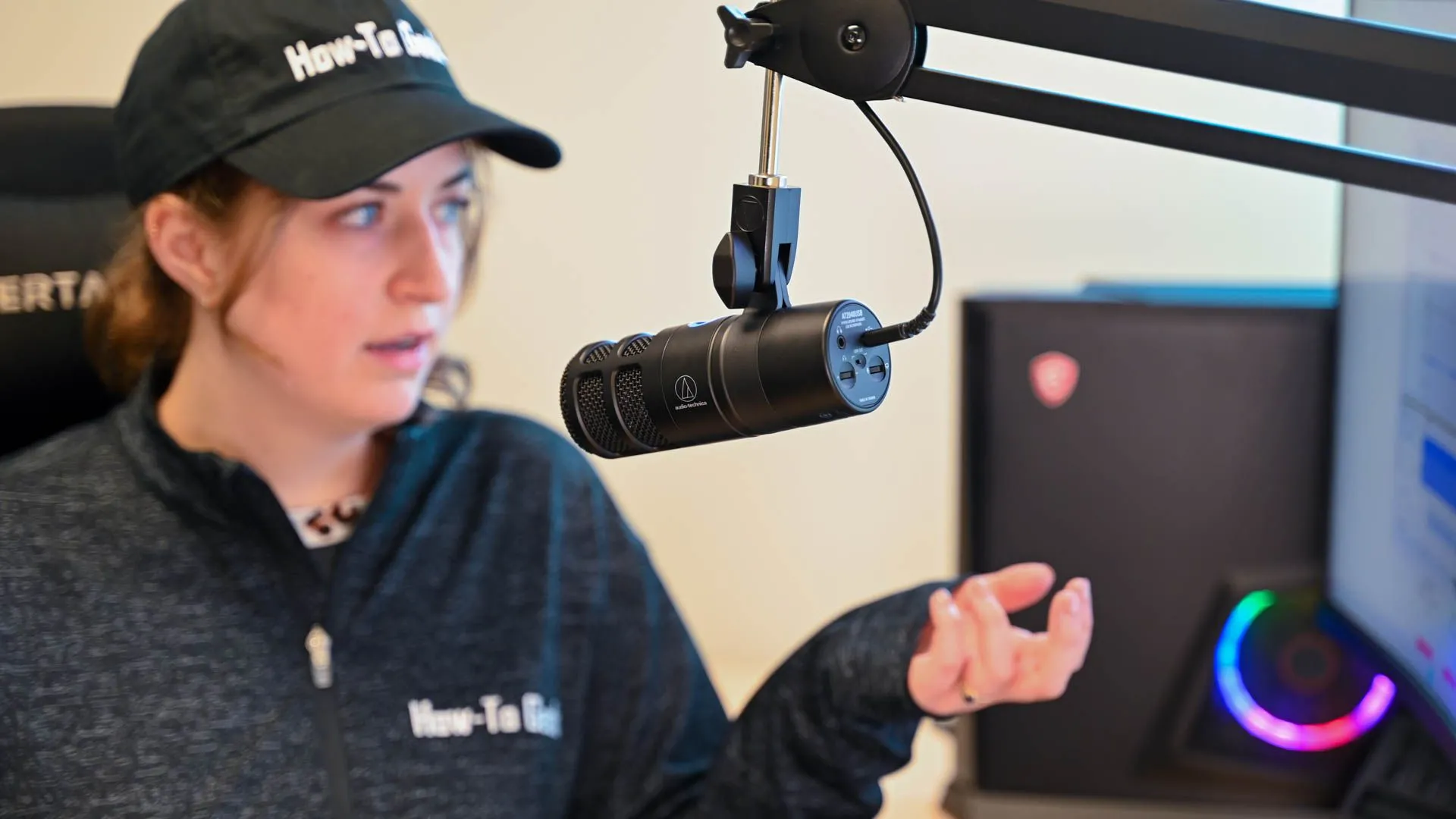 Người đang nói vào microphone Audio-Technica AT2040USB, một ví dụ về mic thu âm chuyên nghiệp với kết nối có dây ổn định.