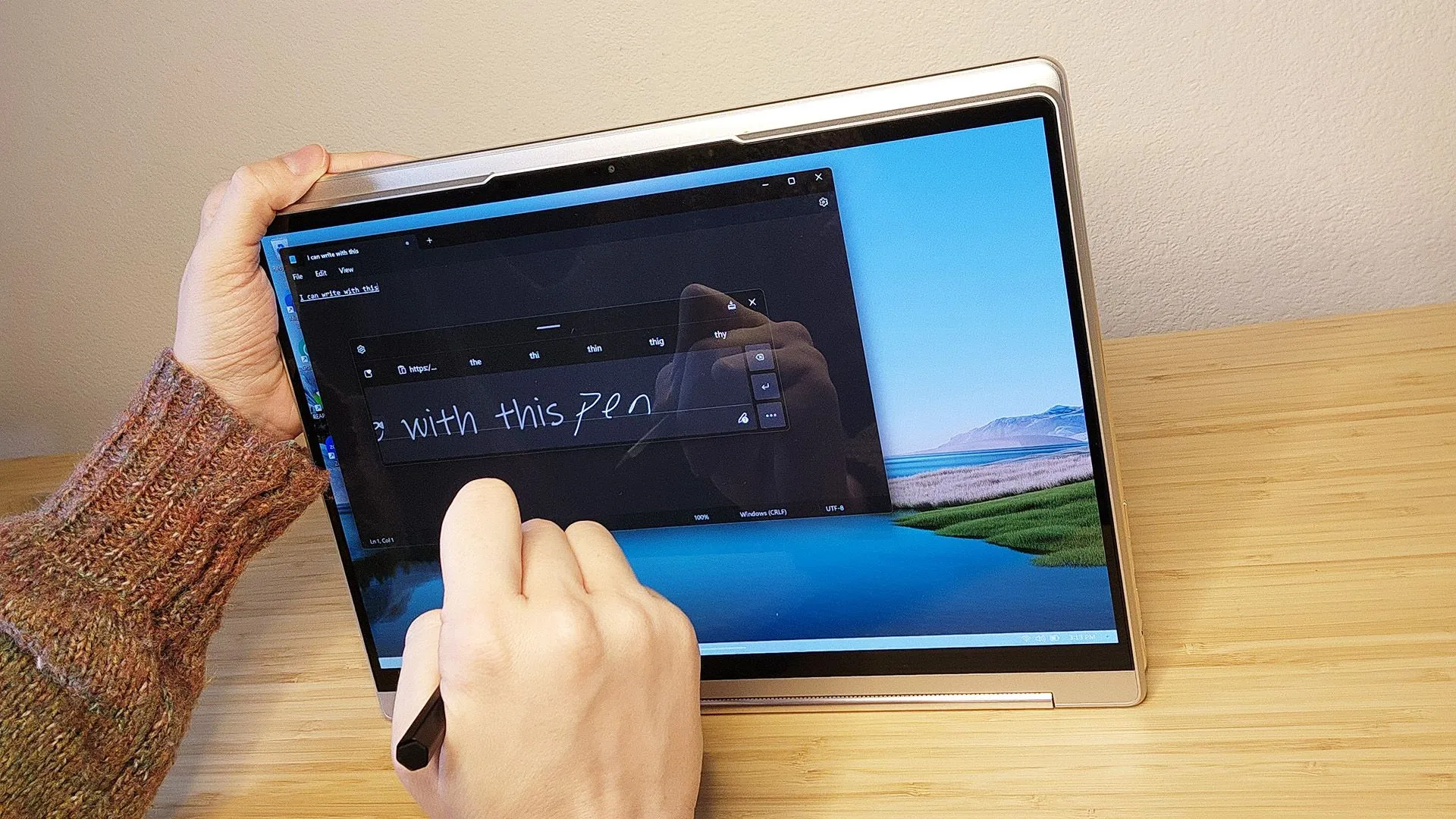 Người đang viết hoặc vẽ trên màn hình laptop Lenovo Yoga 9i Gen 8 bằng bút stylus