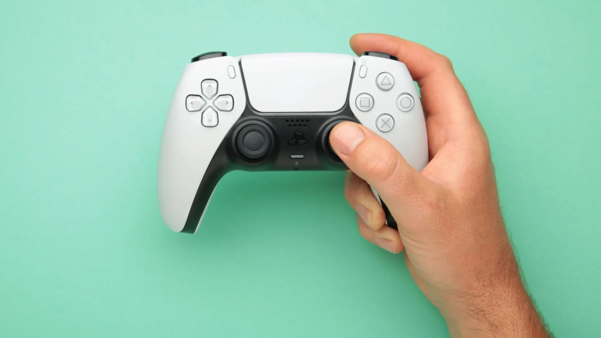 Người dùng đang cầm tay cầm không dây DualSense để chơi game