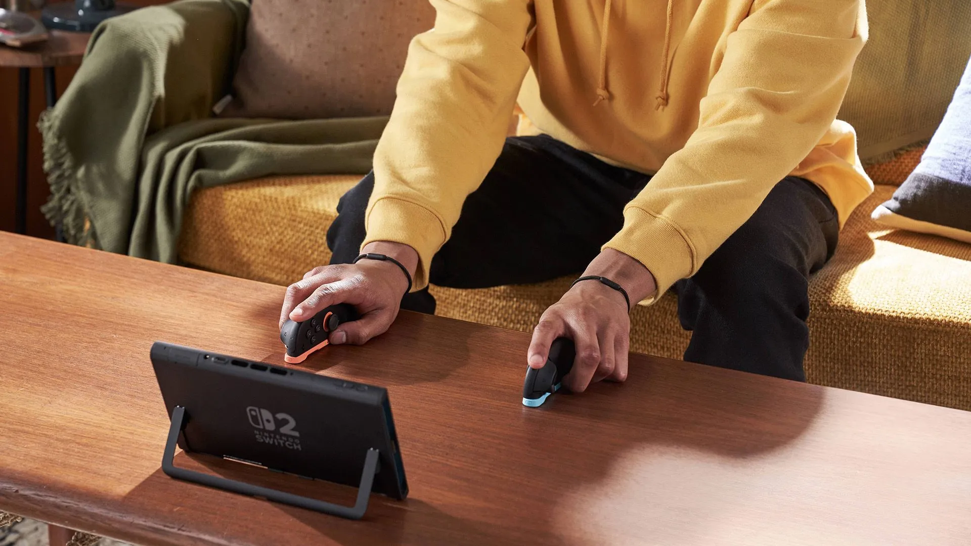 Người dùng đang trải nghiệm chơi game trên Nintendo Switch 2 ở chế độ cầm tay, có thể sử dụng bao đựng hoặc tay cầm chơi game chuyên dụng.