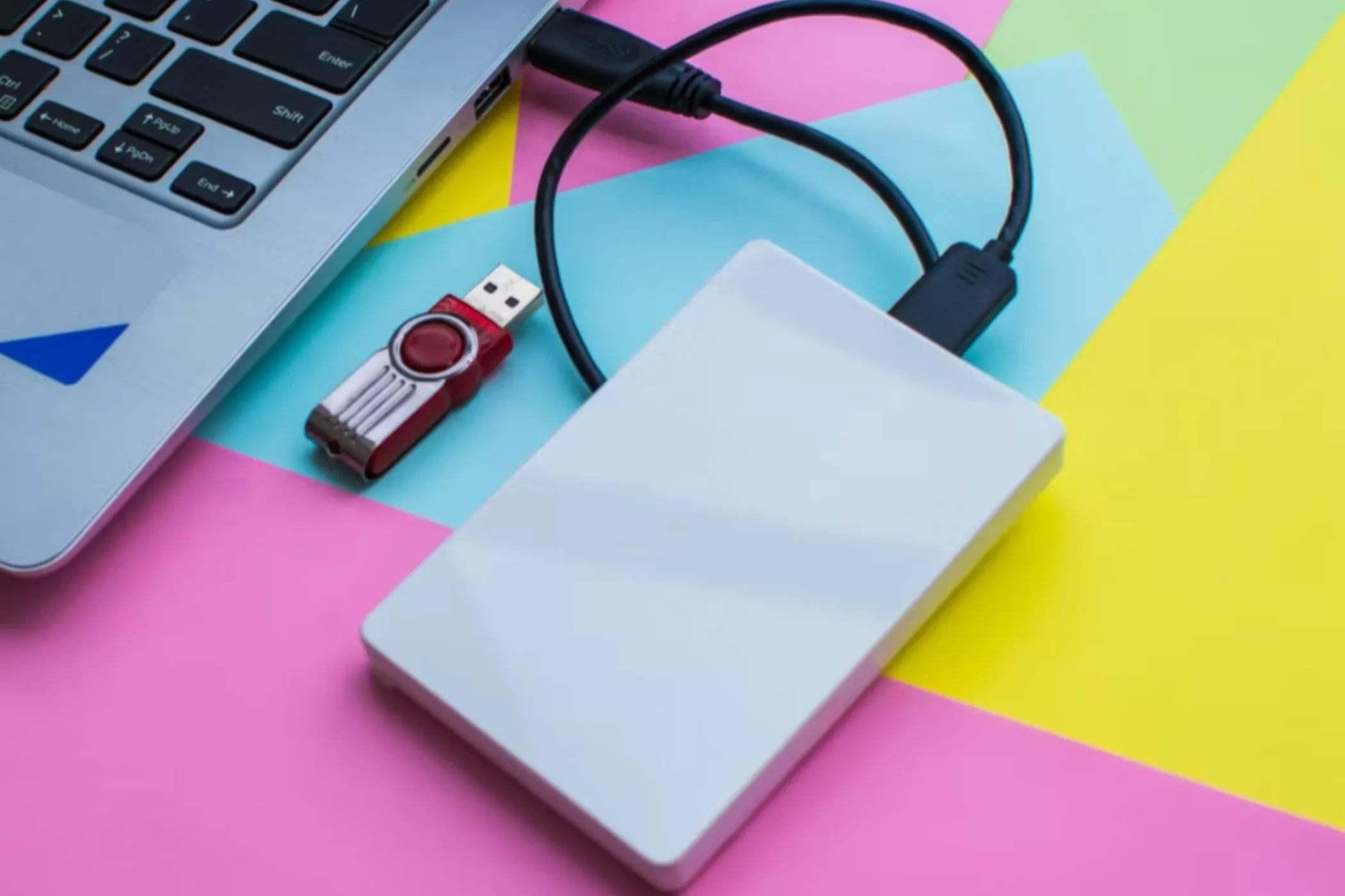 Ổ đĩa flash USB và ổ cứng ngoài được kết nối với máy tính xách tay, tượng trưng cho việc chuyển dữ liệu nhạc số