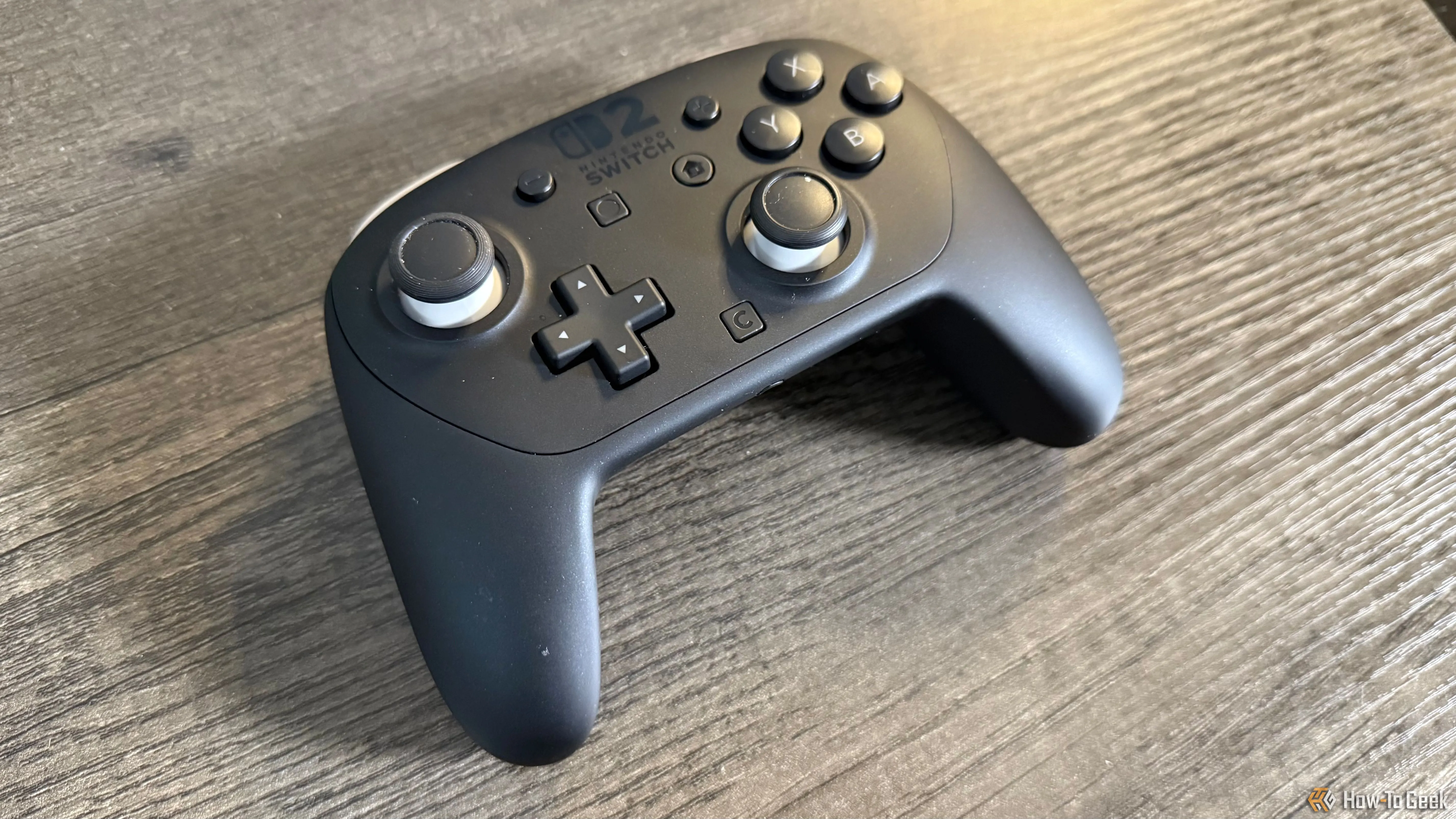 Tay cầm Nintendo Switch 2 Pro Controller màu đen đặt trên bàn, góc nhìn từ trên xuống.