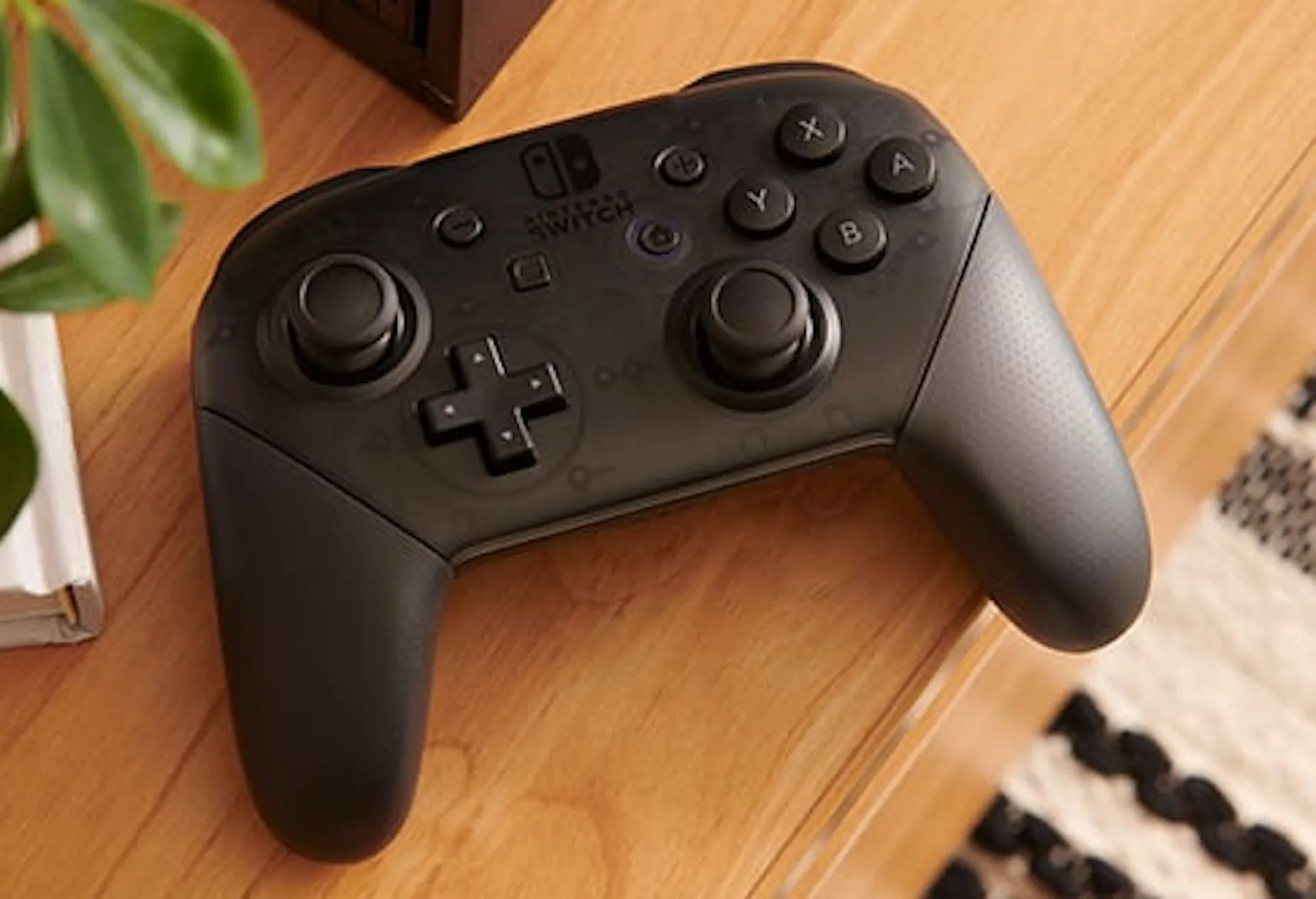 Tay cầm Nintendo Switch Pro Controller đặt trên bàn gỗ, sẵn sàng để cập nhật firmware qua console Switch.