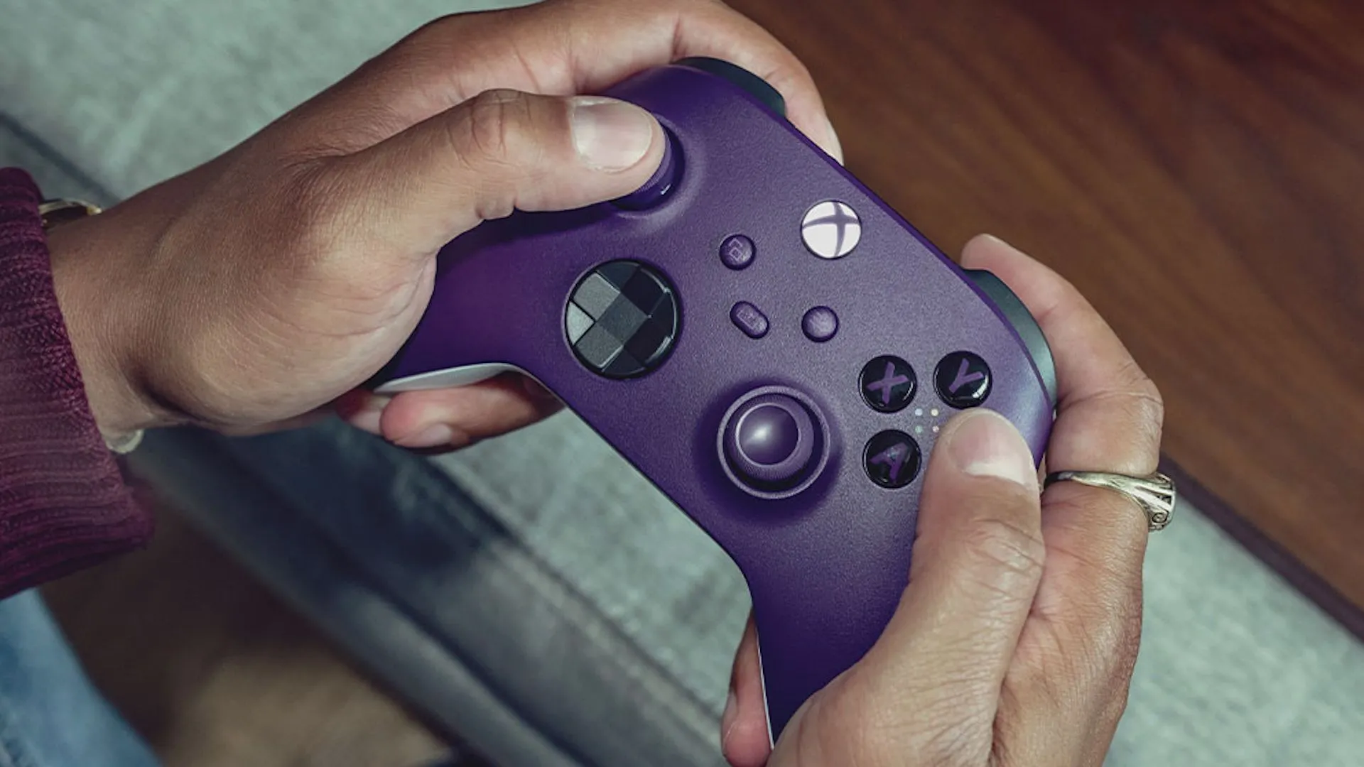Tay cầm Xbox Wireless Controller màu tím được giữ trên tay.