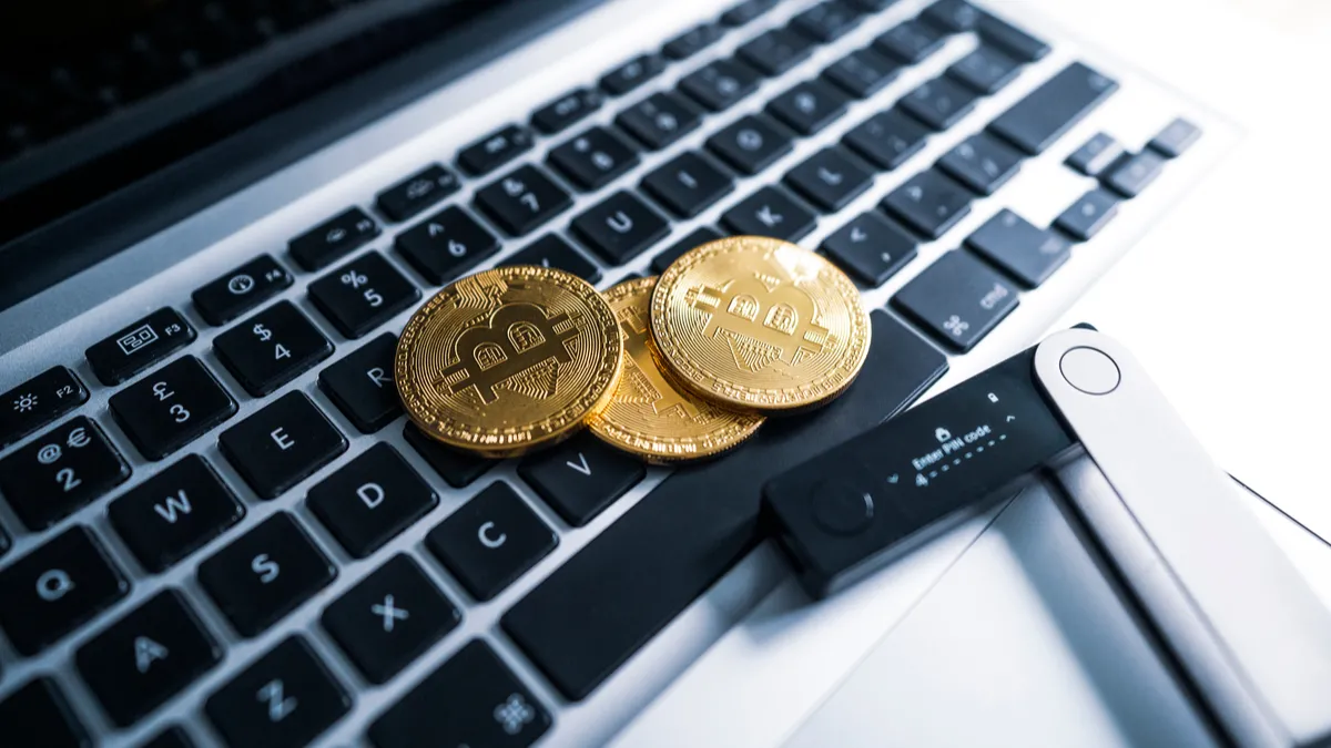 Ví cứng Ledger trên bàn phím laptop, biểu tượng cho việc bảo vệ tài sản kỹ thuật số