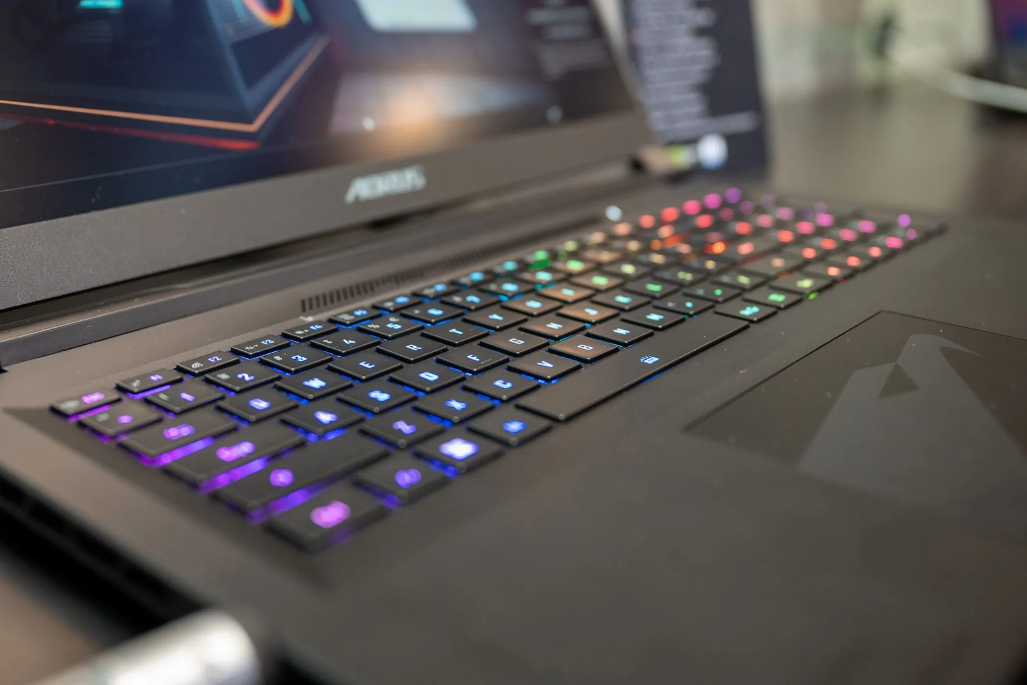 Bàn phím RGB trên laptop gaming Gigabyte Aorus với hiệu ứng đèn nền xanh vàng, minh họa khả năng tùy chỉnh và nâng cấp phần cứng.